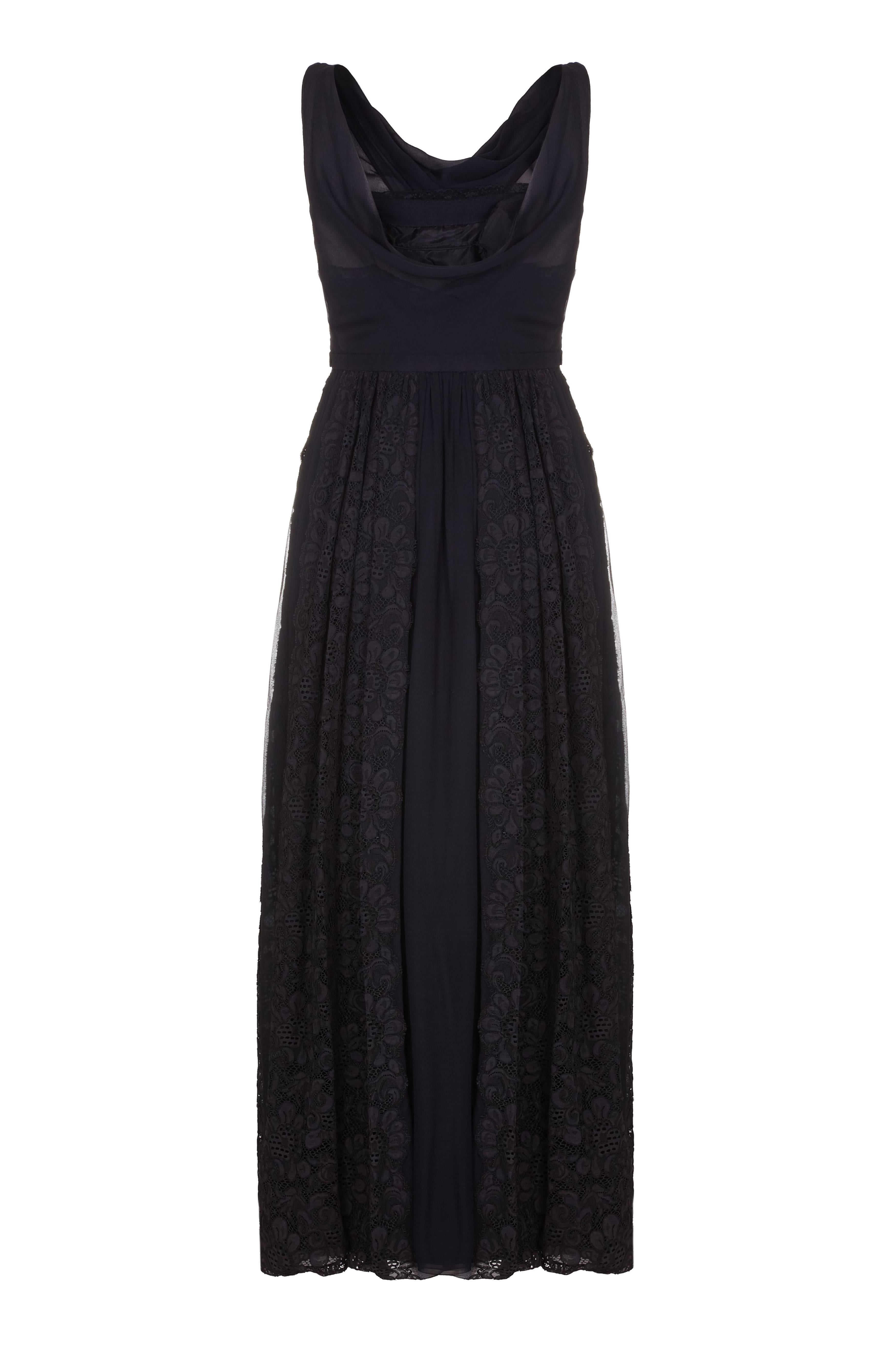 Dieses schwarze Abendkleid aus Seide und Spitze von Mainbocher aus den 1950er Jahren ist von außergewöhnlicher Qualität und weist einige sehr elegante Details auf. Das Mieder ist vollständig gefüttert und die Büste ist leicht gepolstert, um