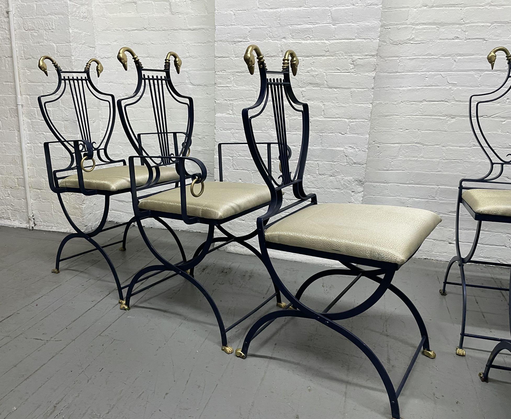 Set of 6 Maison Jansen Swan and Lyre Back Chairs. The folding chairs have brass swans to the top on each side. The frames of the chairs are dark blue with claw feet. Two of the chairs have arms. The chairs can also be used as dining chairs.  Can be