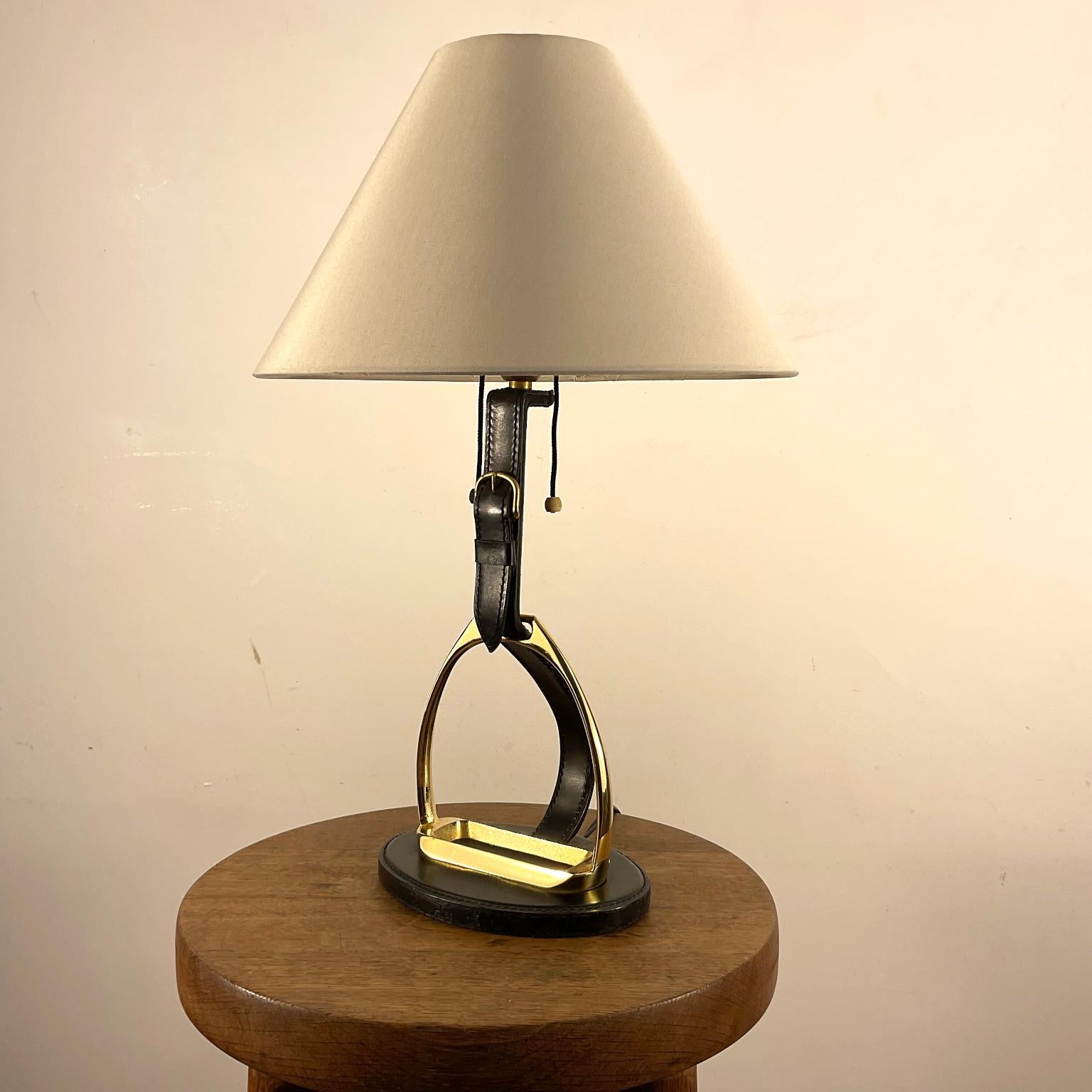 Lampe de table des années 1950 de la Maison Longchamp France.
Monture recouverte d'une finition en cuir noir cousu sellier avec une boucle décorative en laiton et un étrier en laiton massif.
Signé sous sa base 