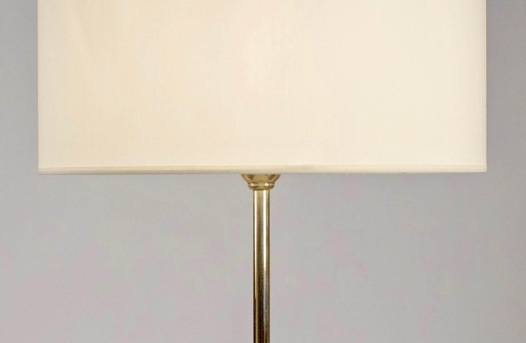 1950s Lunel floor lamp made of brass with a tripod base.
The three feet are black lacquered and ended by three brass balls.
Handmade shade of off white cotton.

One bulb.