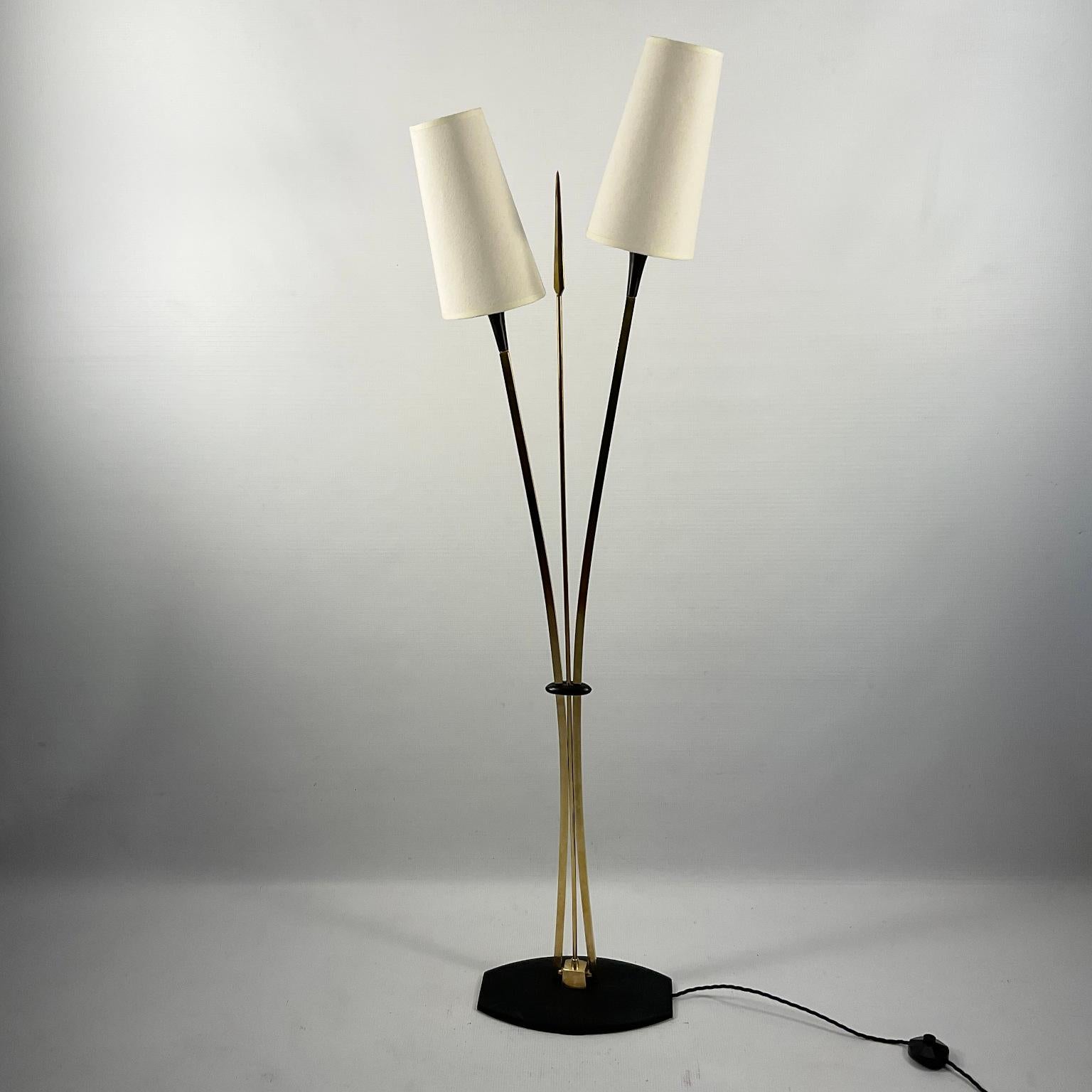 Maison Lunel floor lamp from the 50s with two brass branches topped with two lights and a central decorative brass lance.
On/off foot switch and two linen lampshades included