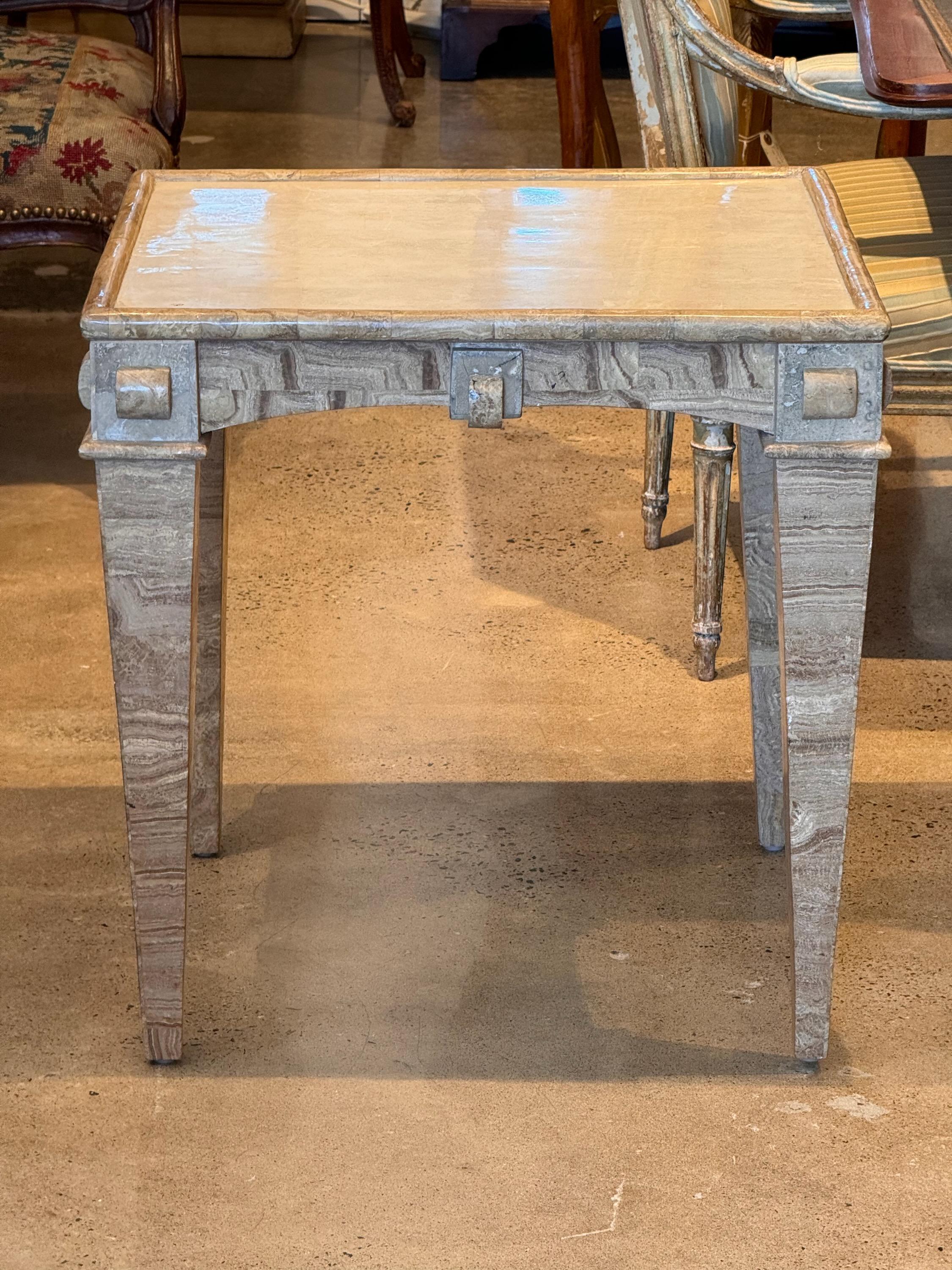 A handsome side table. It is covered in marble veneers .