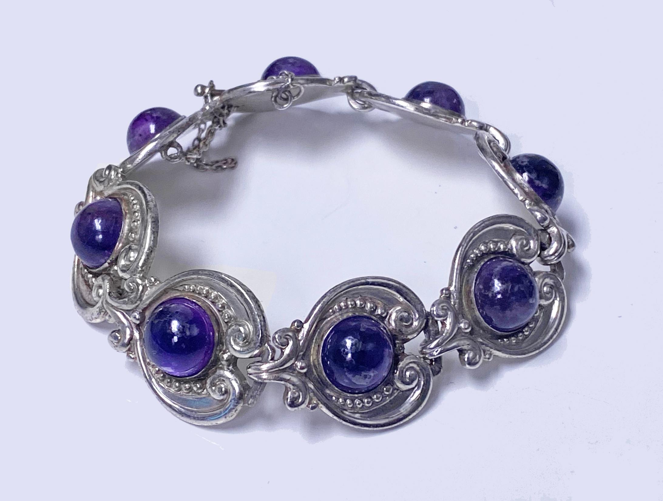 Margot de Taxco 1950’s Sterling Silver and Amethyst Bracelet. Sterling silver articulated bracelet with heart shaped links set with amethyst cabochons, each gauging approximately 10 mm, reverse stamped Margo de Taxco 5210, Sterling made in Mexico