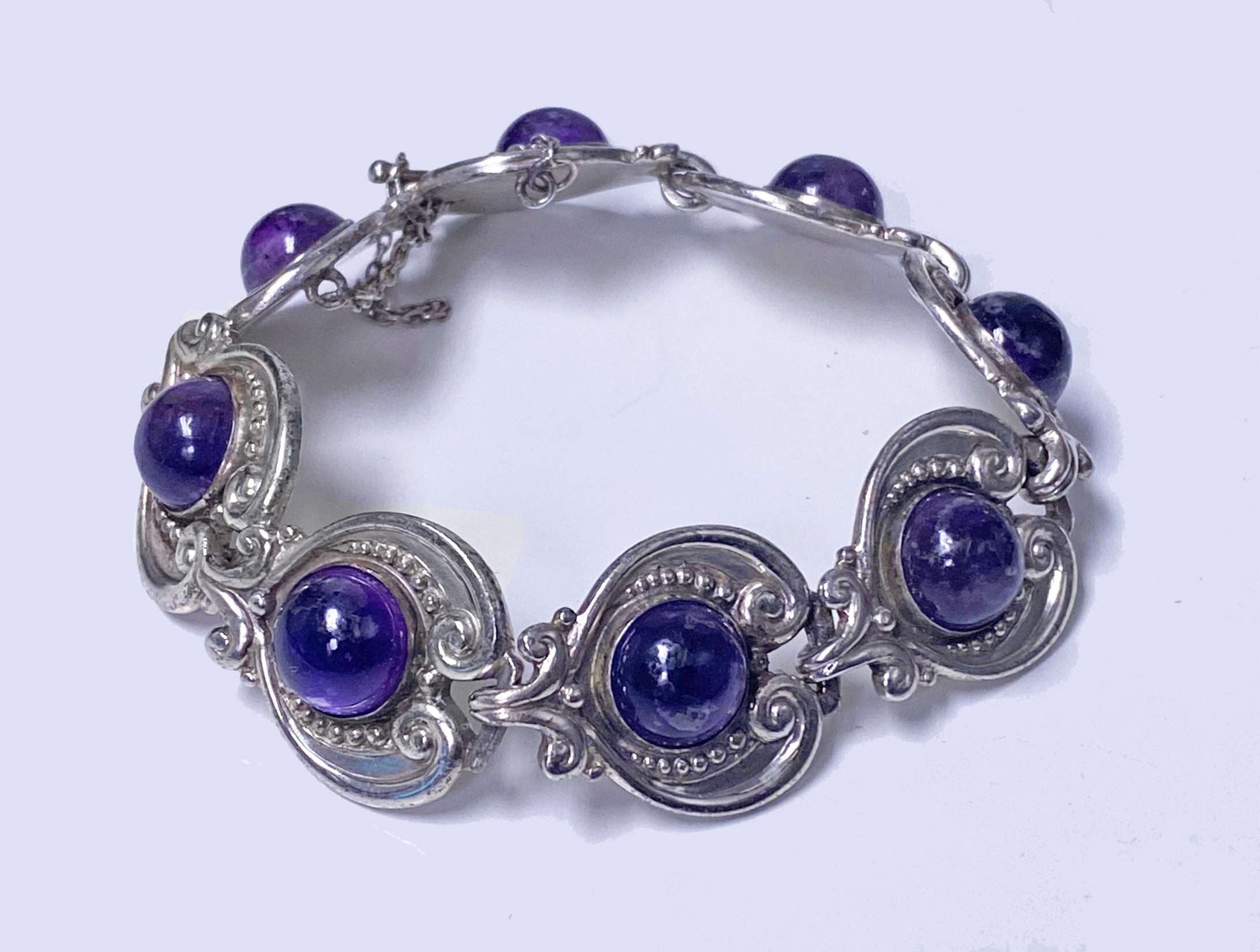 Margot de Taxco 1950’s Sterling Silver and Amethyst Bracelet. Sterling silver articulated bracelet with heart shaped links set with amethyst cabochons, each gauging approximately 10 mm, reverse stamped Margo de Taxco 5210, Sterling made in Mexico