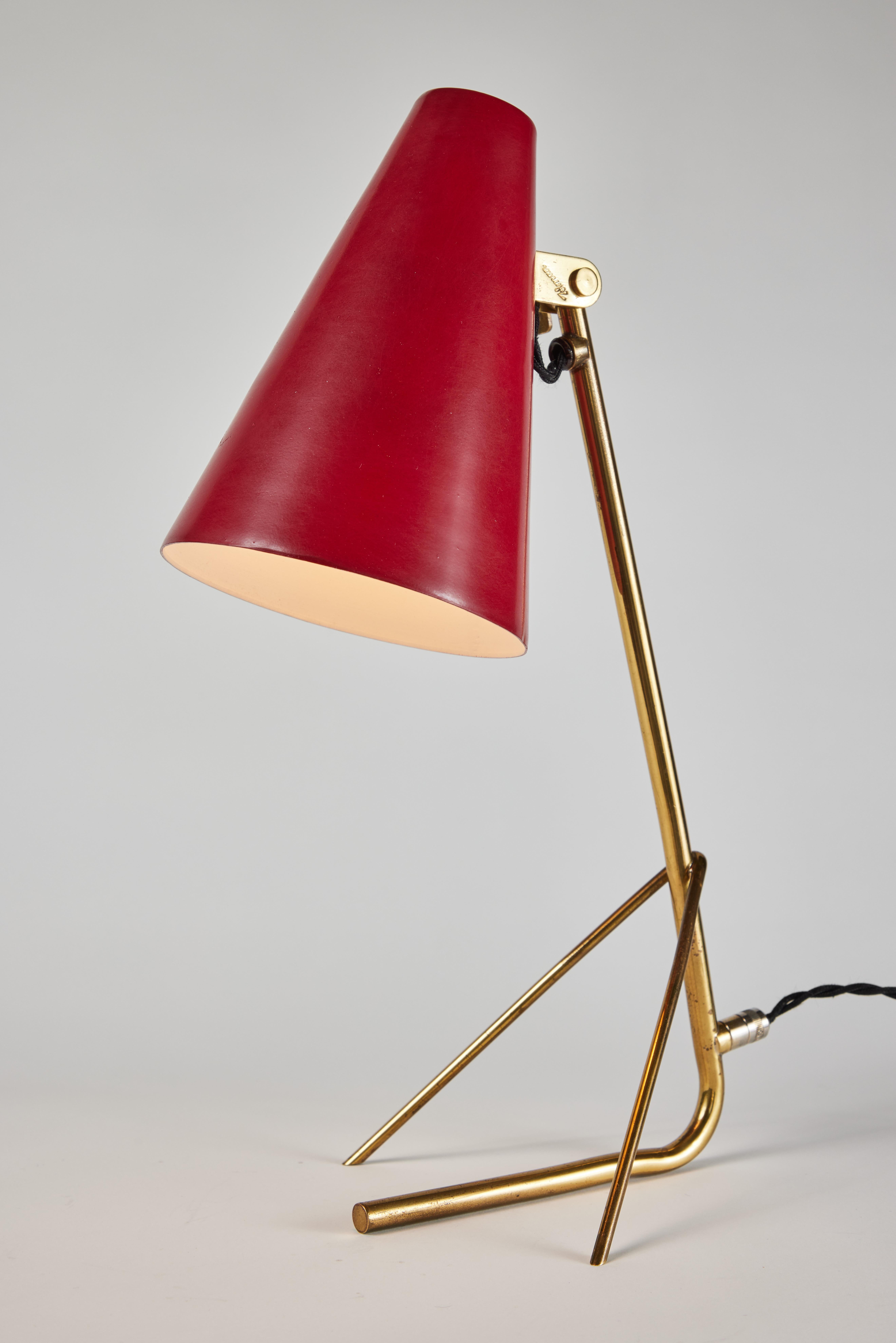 1950s Mauri Almari model K11-17 table lamp for Idman. A rare model executed in red enameled metal and brass. The shades can be raised and lowered. Reminiscent of Paavo Tynell's iconic designs for Taito Oy. An incredibly refined table lamp that is