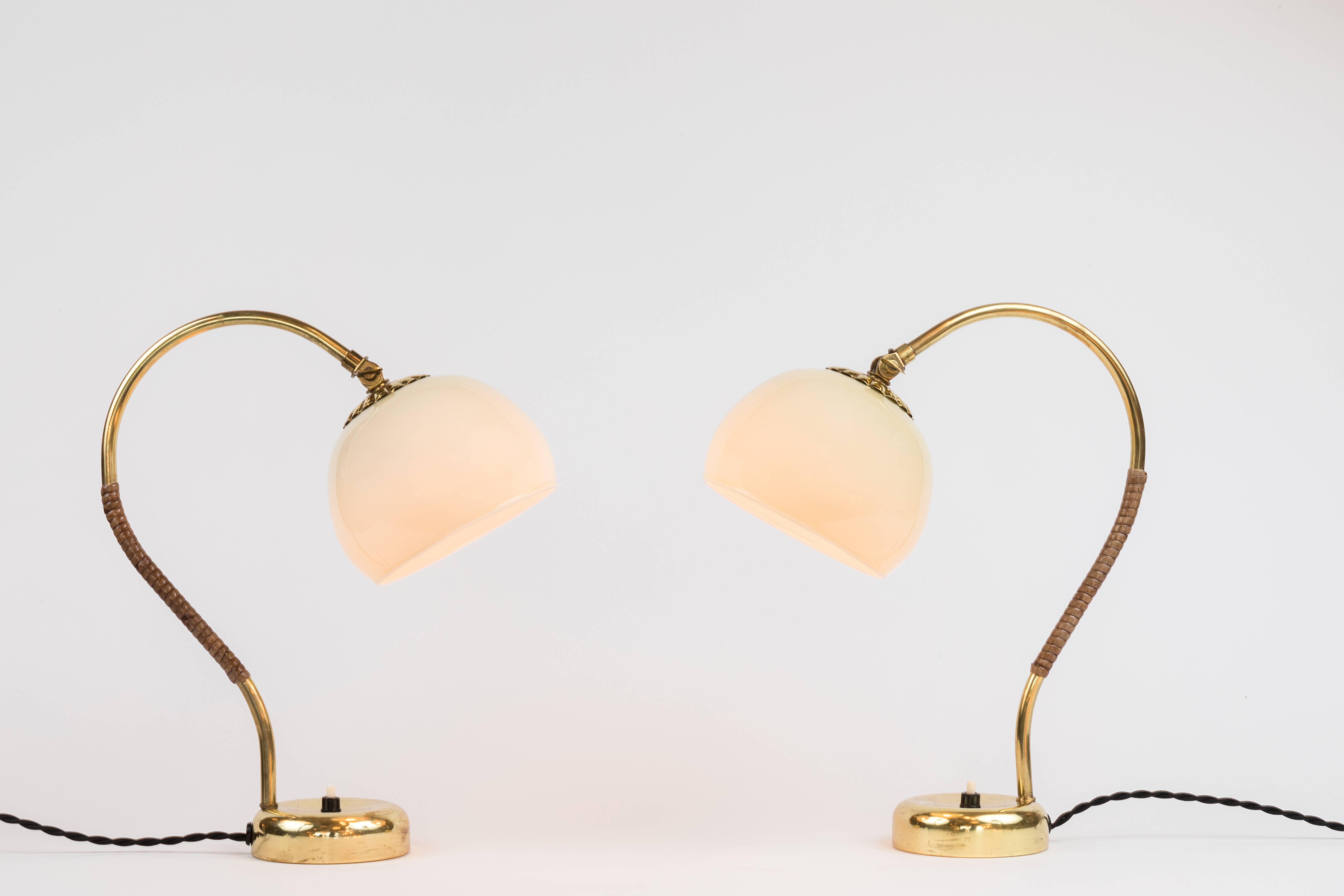 1950s Mauri Almari table lamps for Idman. A rare and elegant pair of lamps executed in brass, blown opaline glass and rattan. A contemporary of Paavo Tynell, Almari's refined work has made him an increasingly valued finish designer in recent years