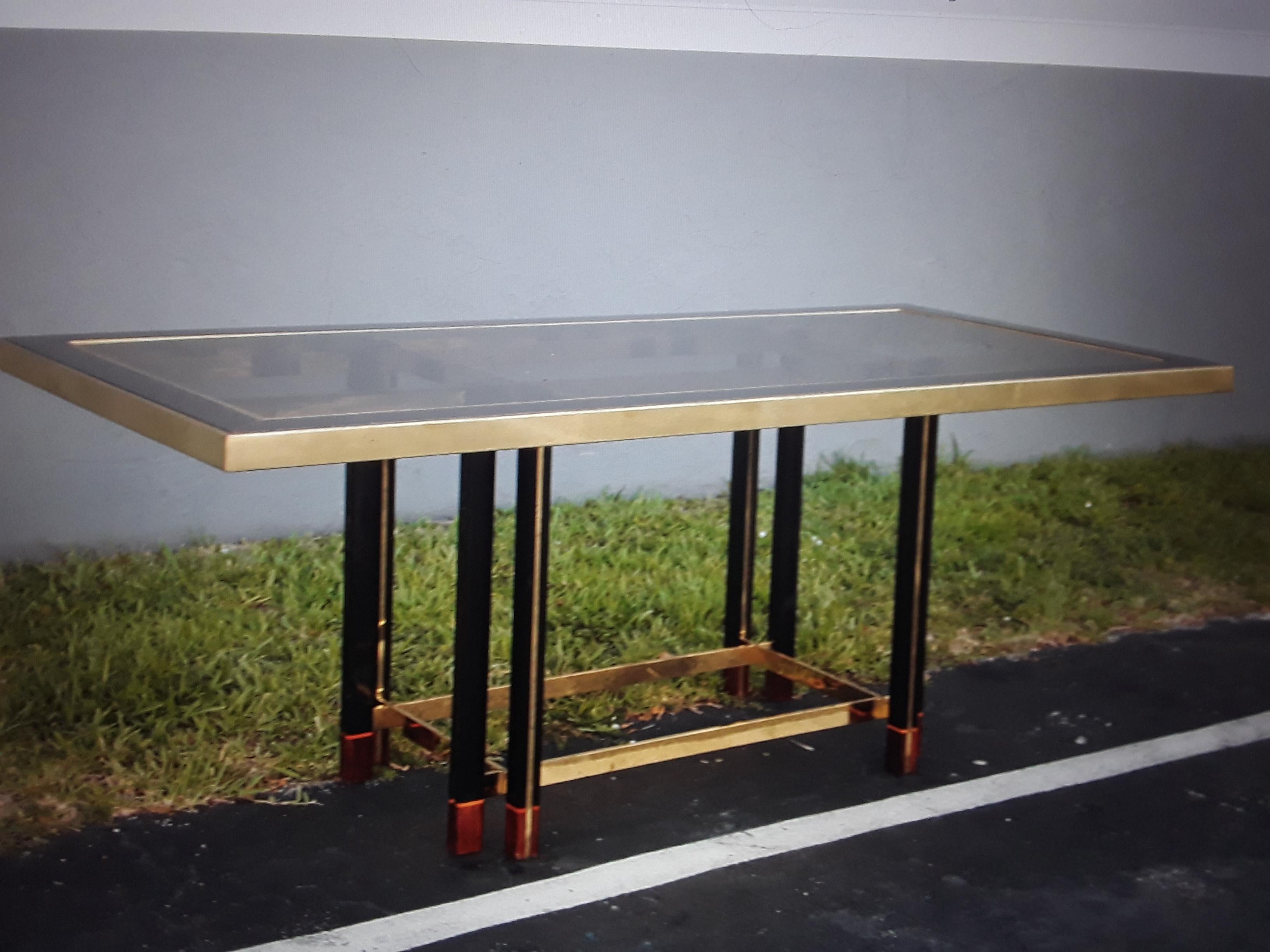 1950's Italian Mid Century Modern Designer Dining Table. Constructed of Brass/ Macassar Ebony wood and Bronze toned Glass. This dining table is signed by 