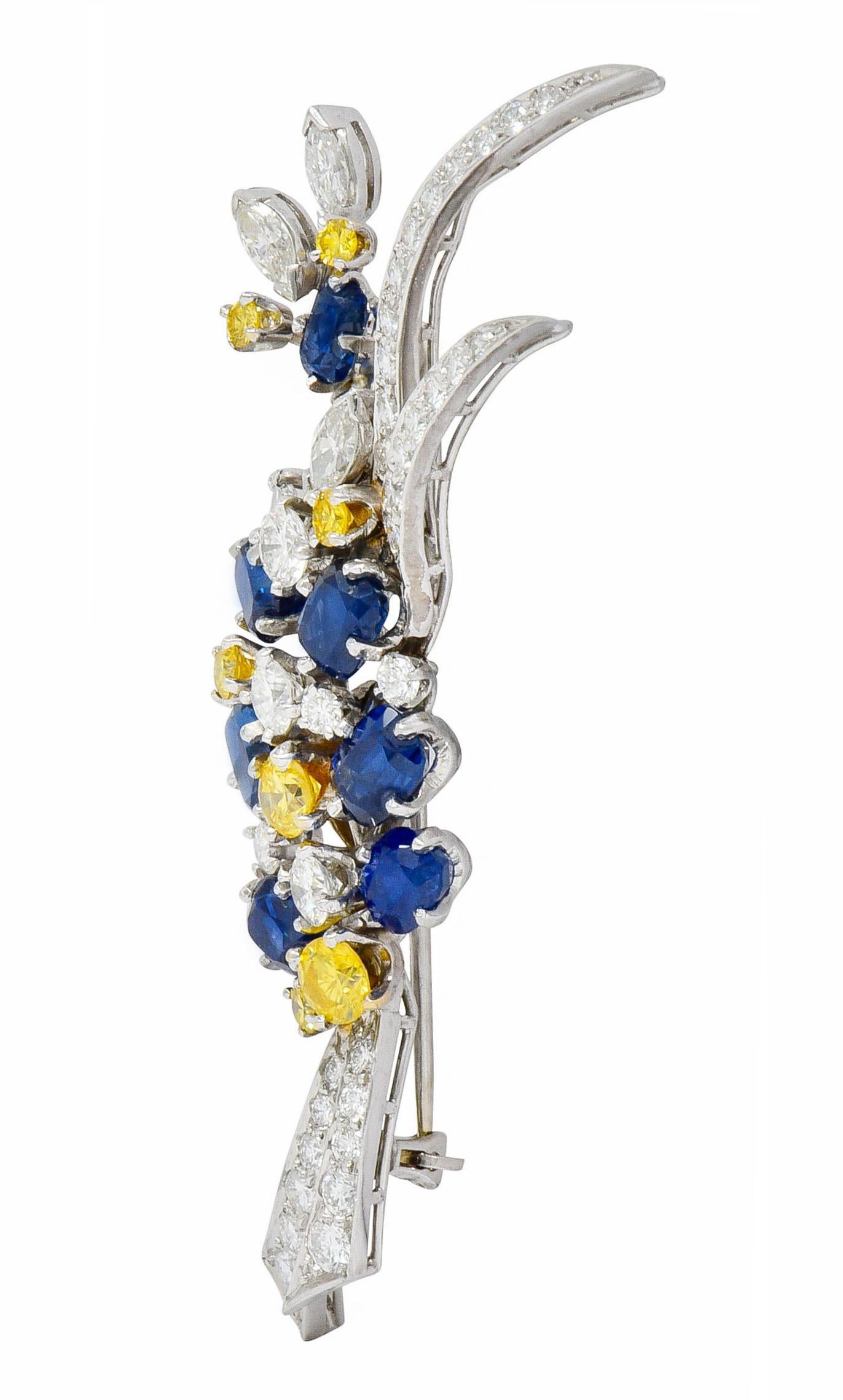 Linear brooch is designed as a flourishing boutonnière of sapphires, diamonds, and yellow diamonds

Cushion and rectangular cushion cut sapphires are an incredibly well-matched royal blue and weigh in total approximately 3.00 carats

Accented by