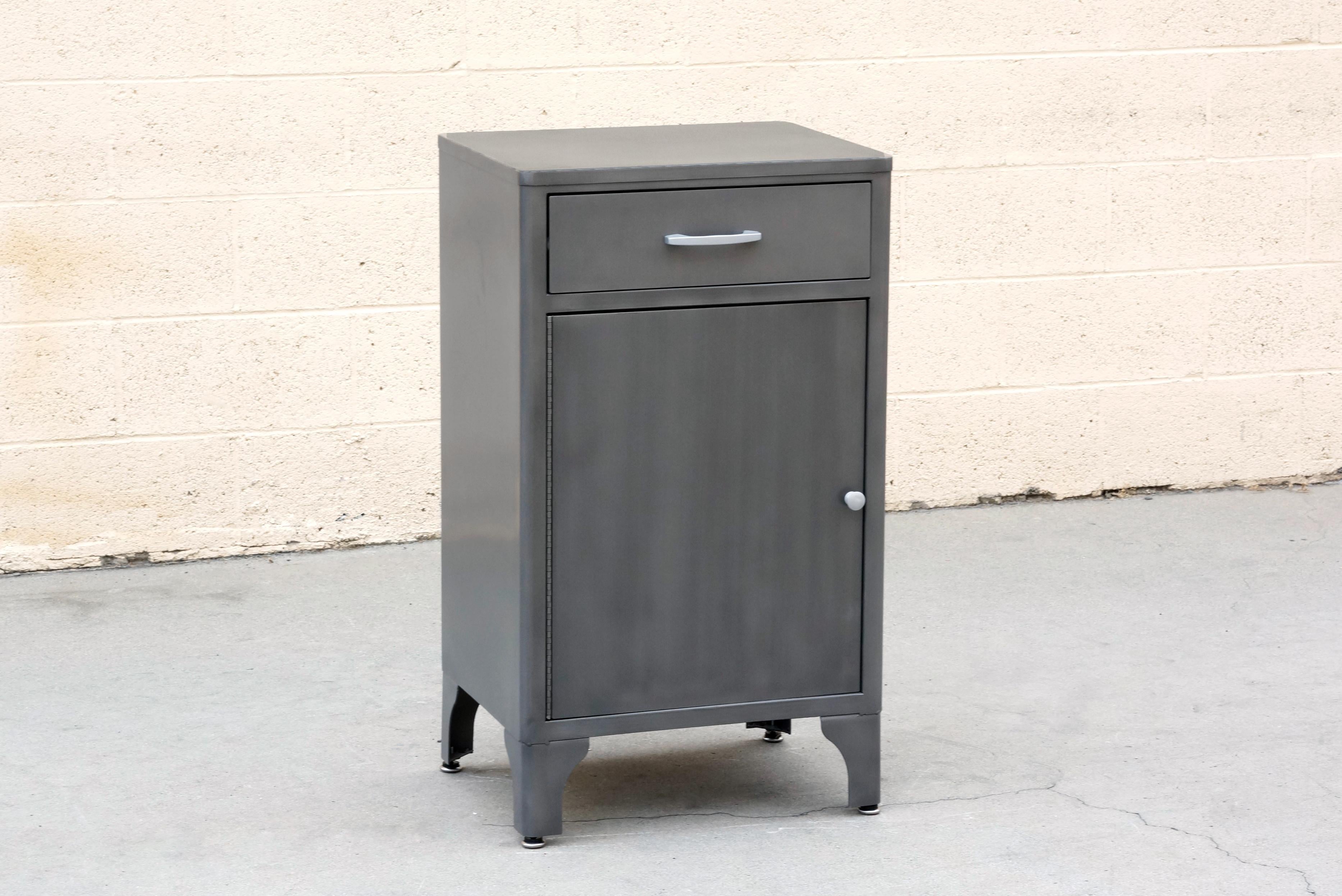 Classic 1950s Industrial medical cabinet refinished in a natural steel powder coat. This quality-made steel unit features single drawer and magnetized cabinet door with double shelves. Original hardware, refinished. 

Dimensions: 20