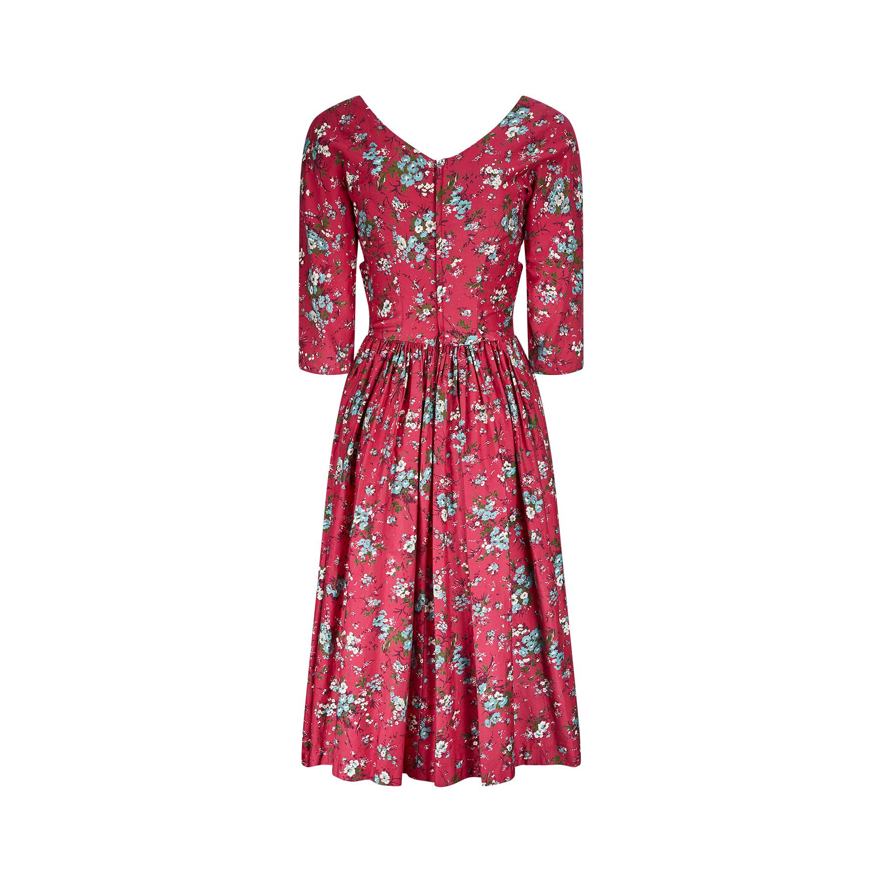 Original 1950s dress from quality British label, Melbray, in a wonderful deep cerise polished cotton. The floral print looks like forget me nots in a brilliant turquoise and white which contrasts beautifully with the pink background. This dress has