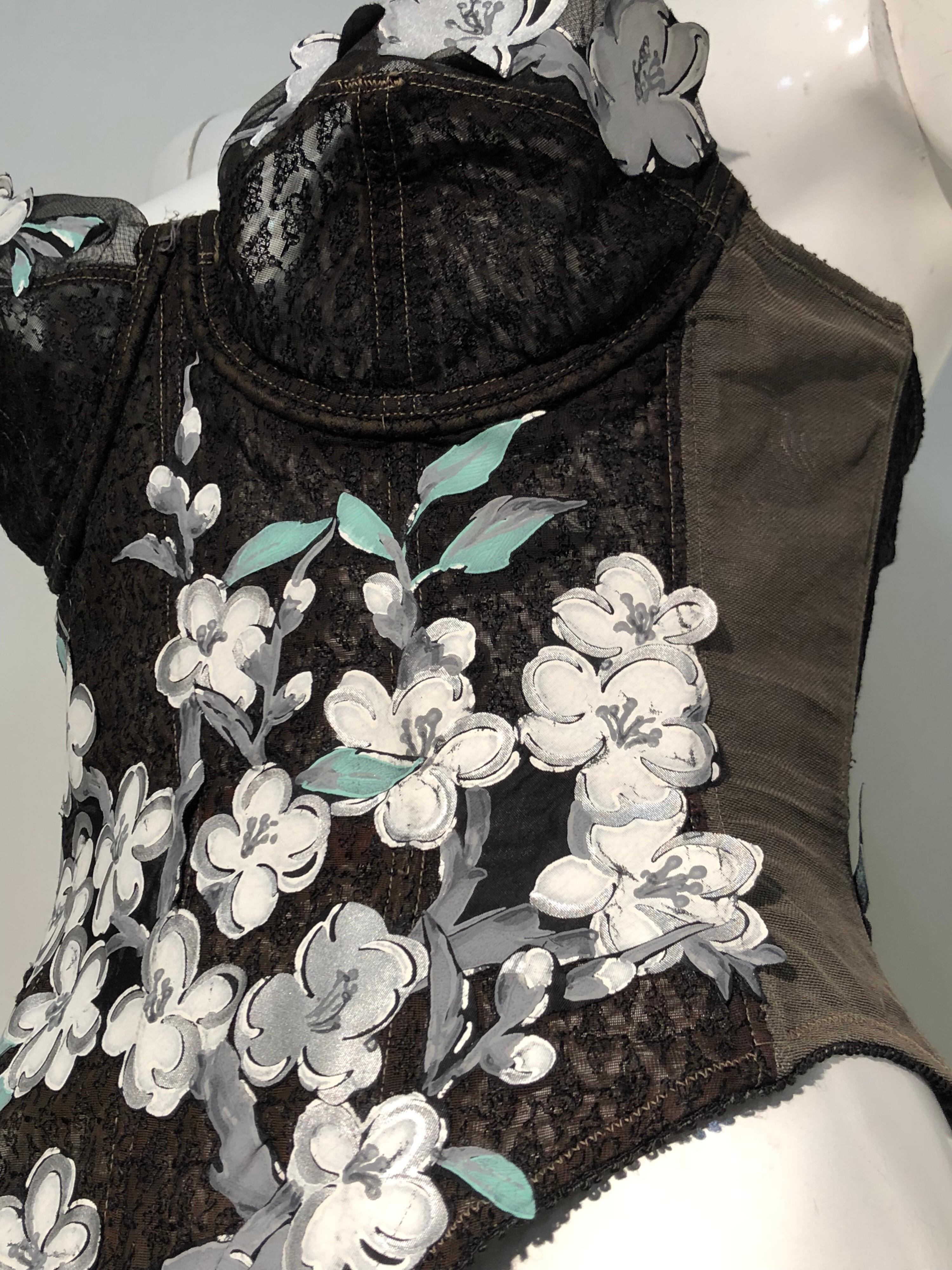 Une Veuve joyeuse Warner des années 1950, sans bretelles, embellie par Torso Creations avec des gerbes florales de cornouiller découpées et appliquées en soie.
Taille 36