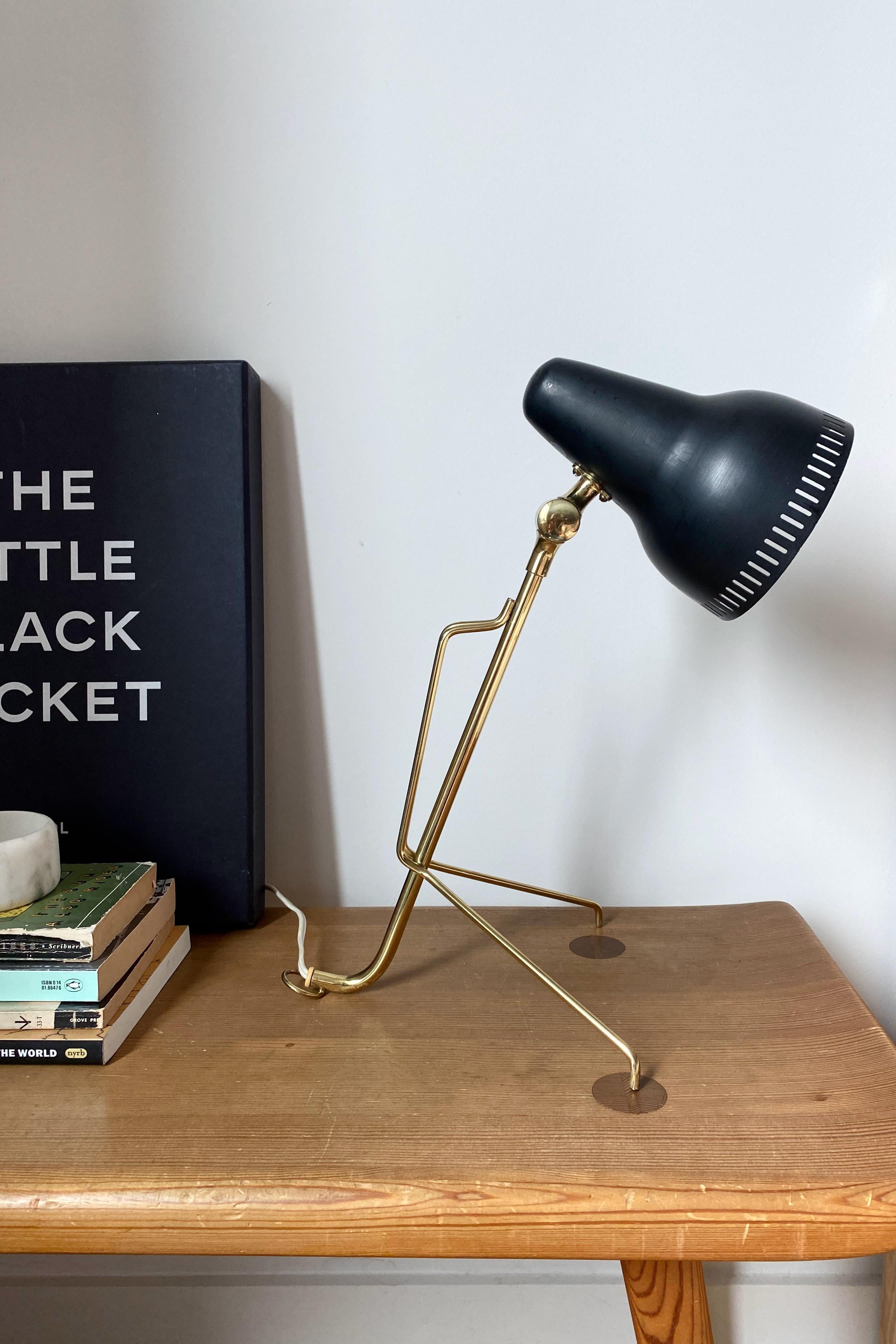 Beautiful 1950's Metal and Brass Table lamp by Falkenbergs, Sweden. 2 brass spider legs support the lamp arm and create a unique look. The adjustable lamp shade is of metal and in original black color with small buckles and marks, please see photos.
