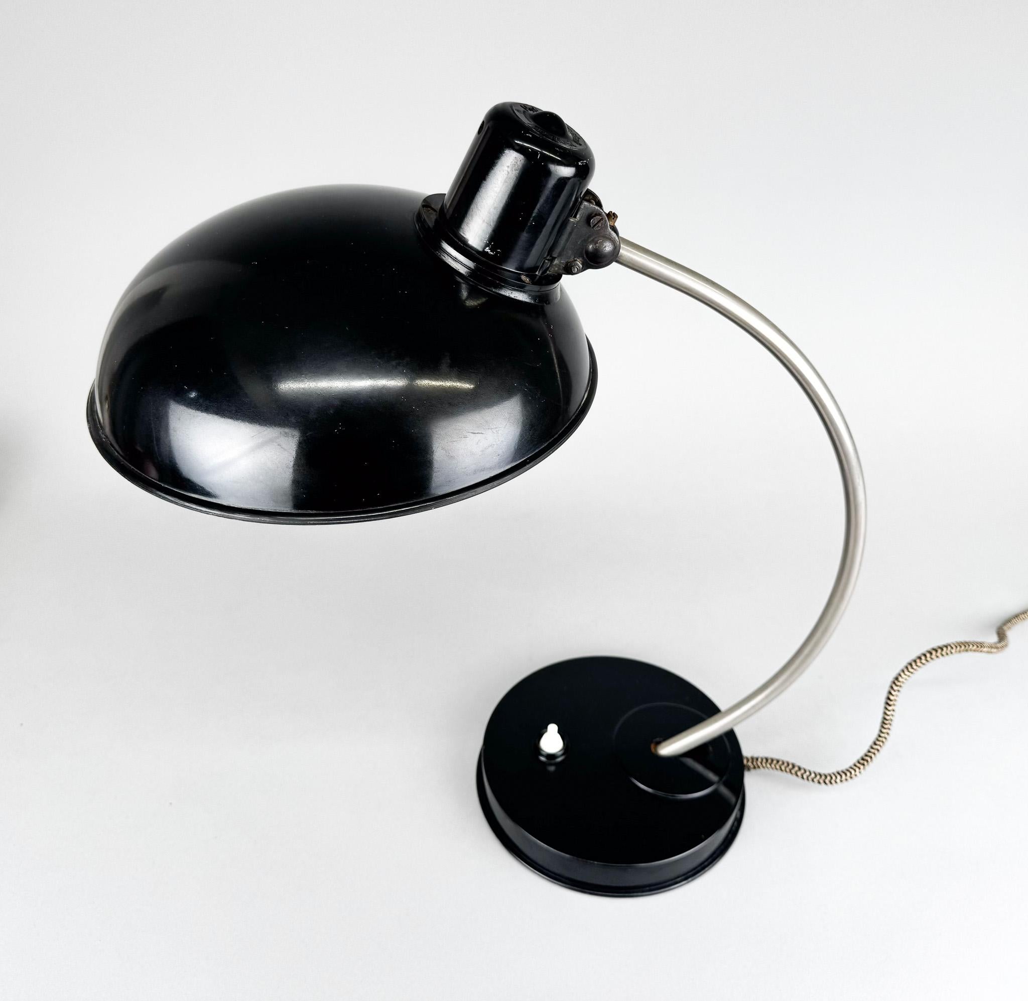 Lampada da tavolo o da scrivania della metà del secolo scorso di Helion. Prodotto in Germania negli anni '50. Il paralume può essere regolato come si vede nelle foto. Etichettato. 
Lampadina: 1 x E27 (E26). Adattatore USA incluso.
