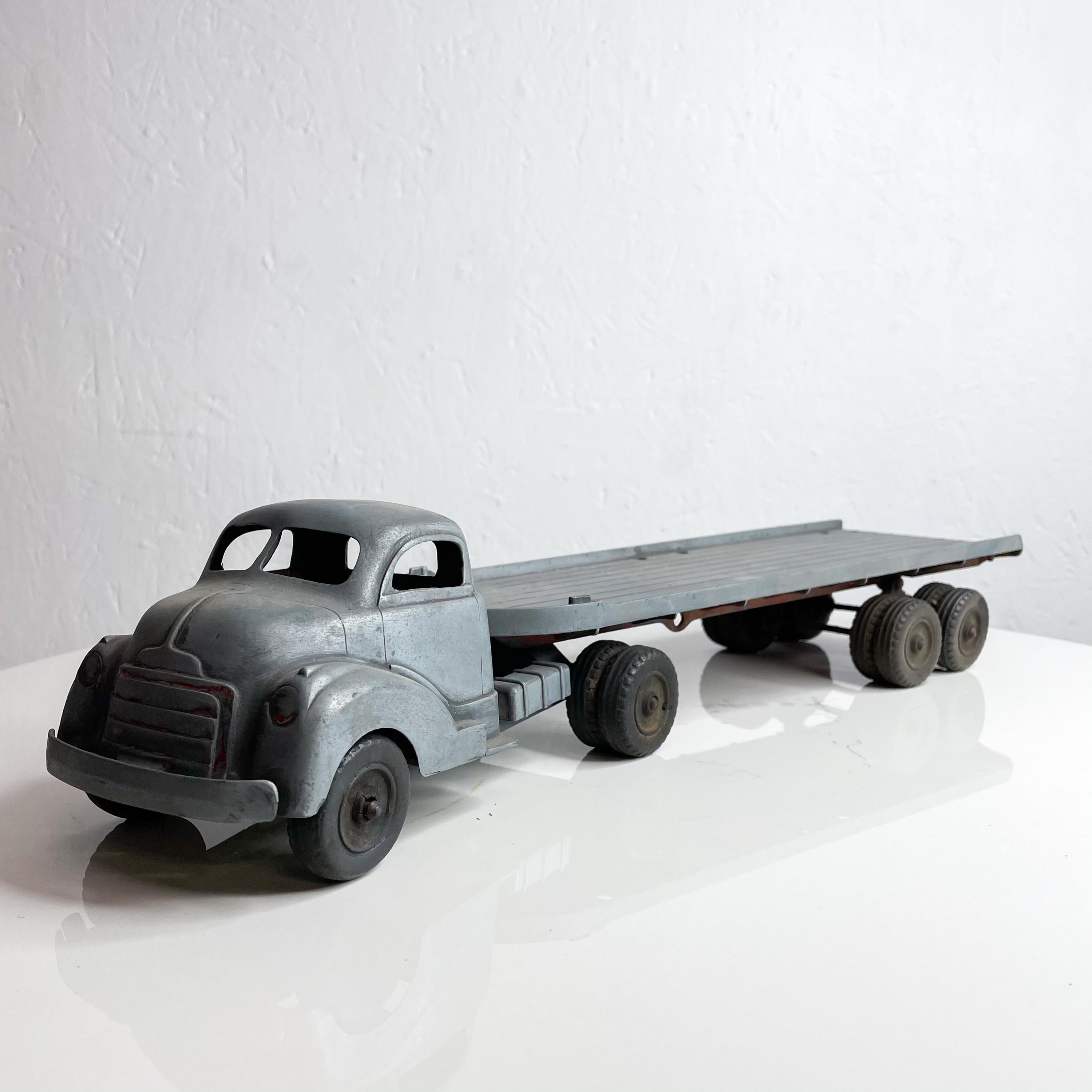 Fab 1950s Vintage toy stake metal truck 14 wheeler super long open flat bed trailer cargo loading.
Cool matte gray. Paint originally Red now matte gray. Big rubber tires.
Attributed to HUBLEY. Unable to verify stamp.
Measures: 17.5 length x 4.25