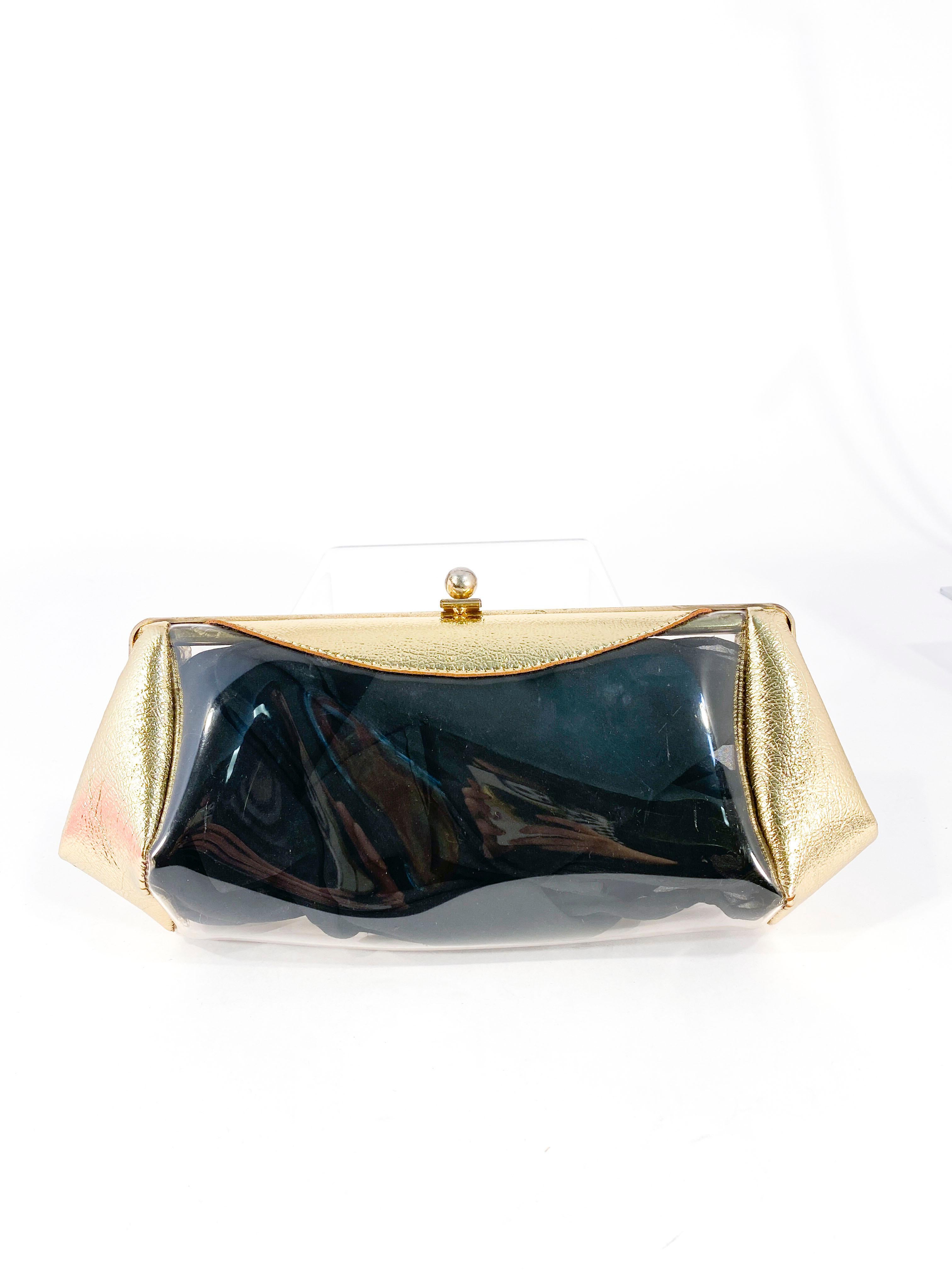 1950s metallic gold leatherette and clear plastic vinyl evening clutch with bras frame. The interior can be interchangeable with colored scarfs to match an evening gown (examples shown but only black scarf is sold with the clutch). 