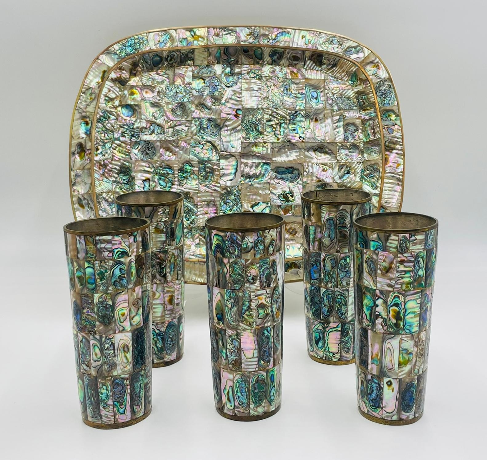 Elegante set da portata messicano di metà secolo in ottone e conchiglia di abalone, composto da un vassoio rettangolare e da cinque bicchieri alti, realizzati a mano in Messico negli anni '50. Ogni pezzo è contrassegnato con la scritta 