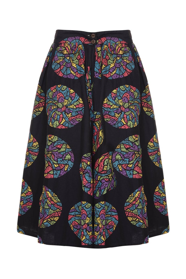 This charming original 1950s Mexican black cotton festival skirt with a vibrant circular multicoloured print in green, blue, fuchsia, and yellow tones is in superb vintage condition and is a wonderfully versatile piece. It features a deep forward