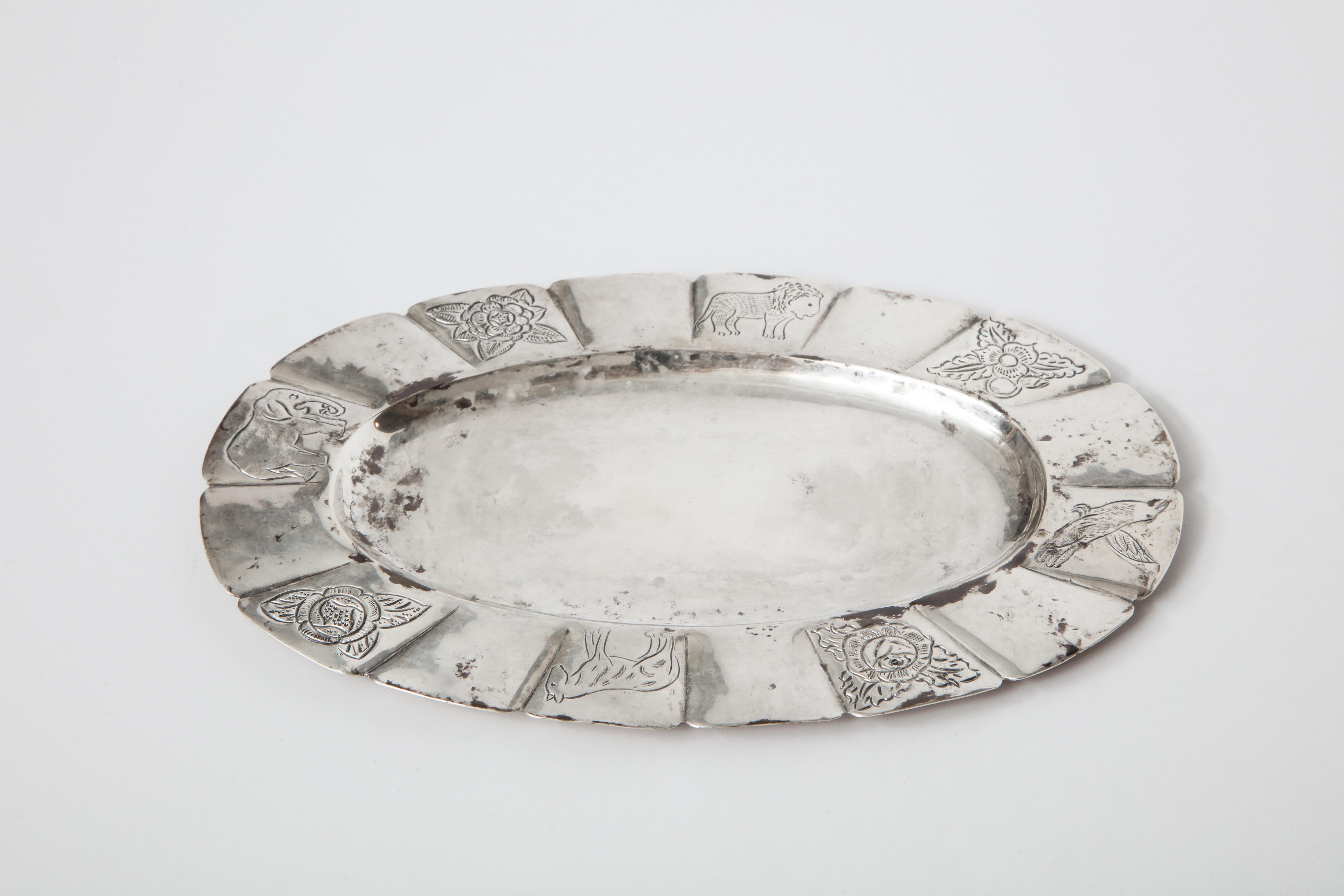 Oval Mexican sterling silver dish with flora and fauna hand-engraved border, circa 1950s. Signed Sanborns.