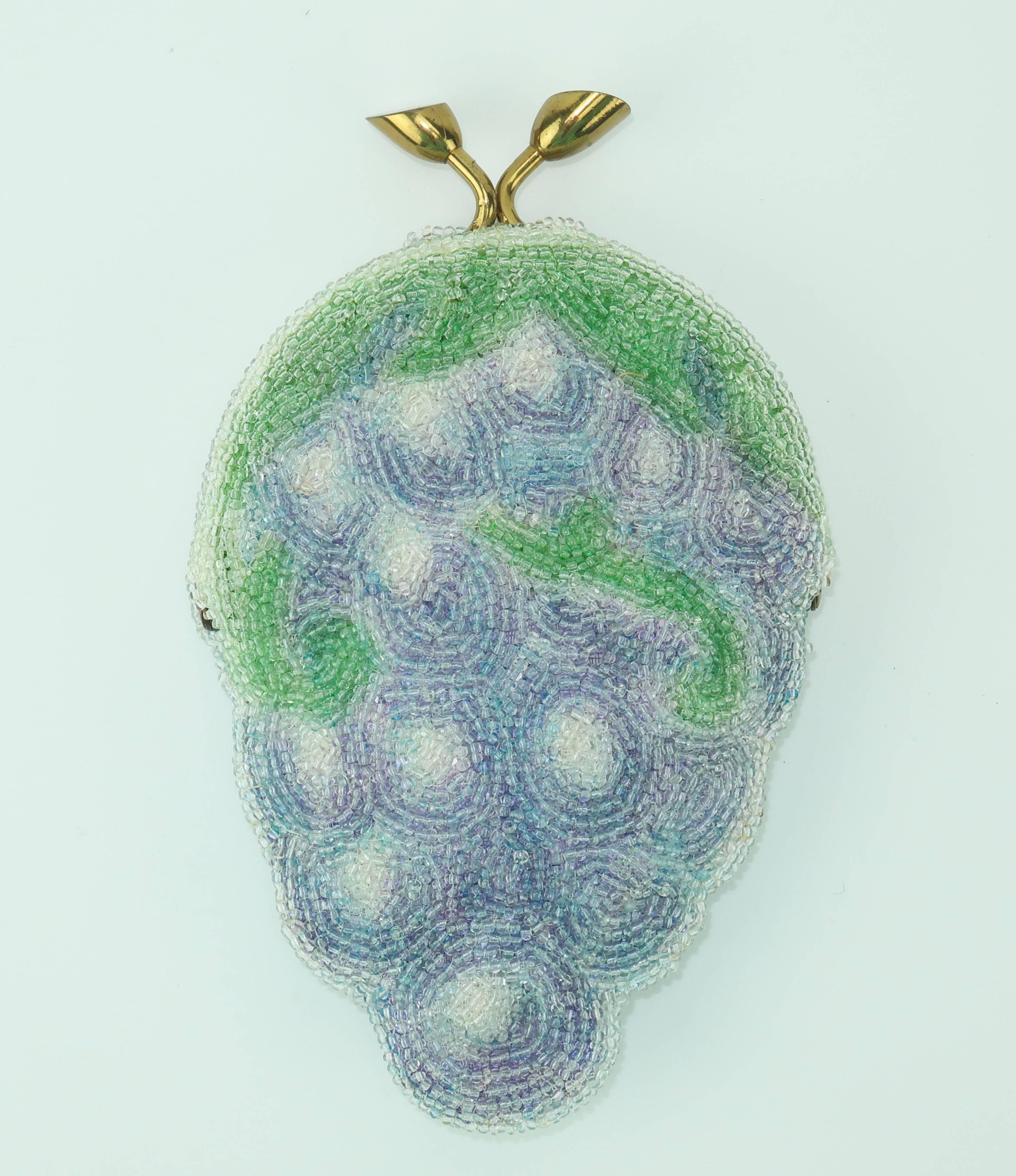 The charm of this novelty change purse will bring a smile to your day.  It is beautifully handmade with micro beads to form an impressionist style grape image and opens with a brass kisslock stem shaped closure to reveal a satin lined interior.  The