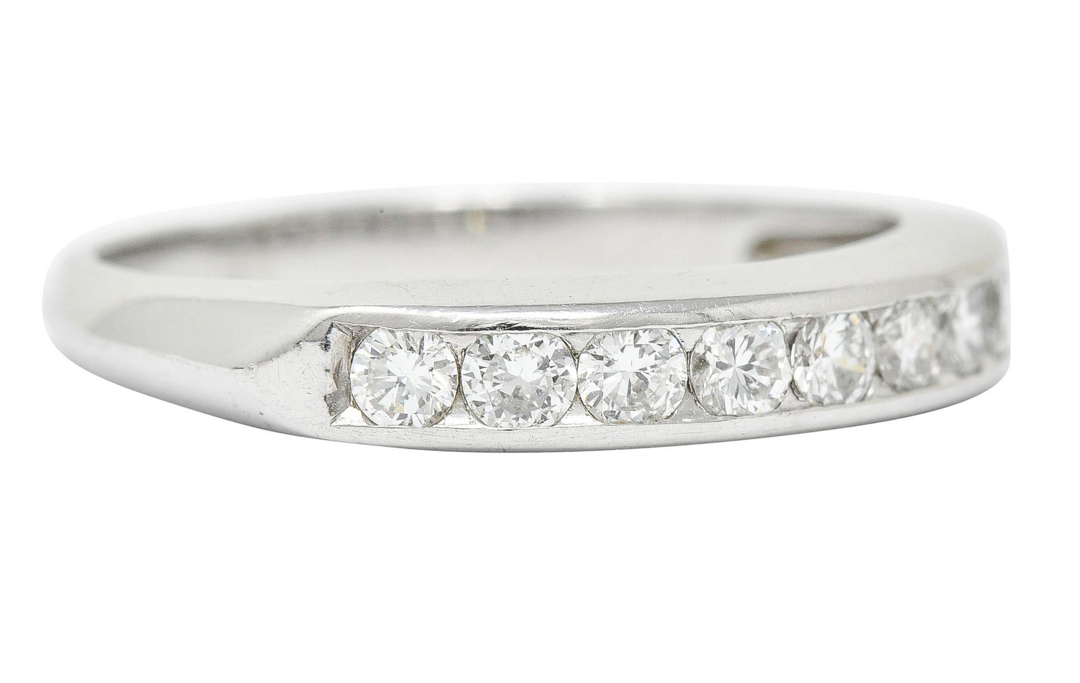 Band ring is channel set to front with nine round brilliant cut diamonds

Weighing in total approximately 0.50 carat with G to I color and VS clarity

With pointed shoulders and a knife edge partially down shank

Stamped for platinum

Circa:
