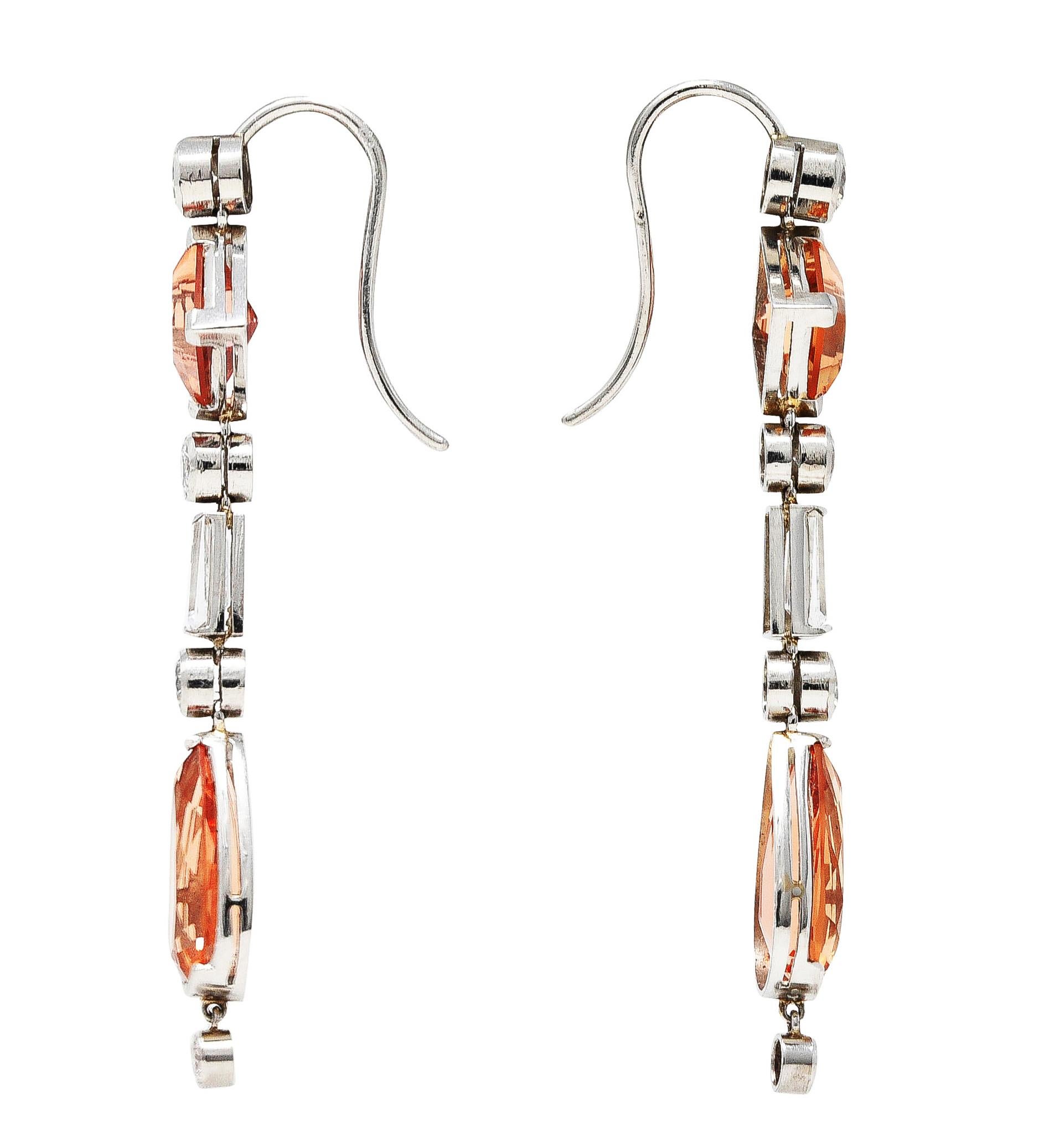 Drop earrings are comprised of geometric gemstones. Bezel, bar, and basket set as articulated platinum links. Featuring square step and pear cut Imperial topaz weighing in total approximately 9.00 carats. Transparent and well matched in pinkish
