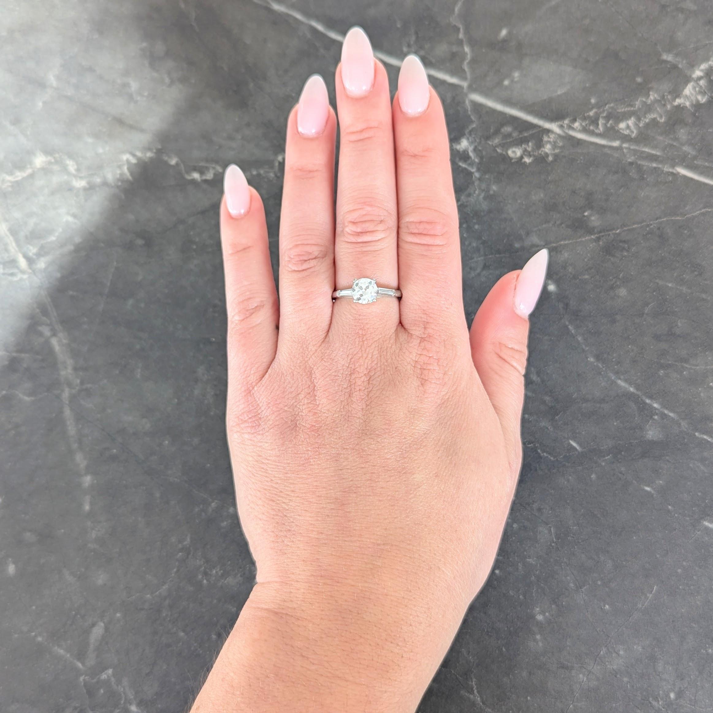 Centering a transitional cut diamond weighing 1.24 carat - H color with SI2 clarity
Prong set in basket and flanked by cathedral shoulders bar set with diamonds
Tapered baguette cut and weighing approximately 0.30 carat total
H/I color with VS