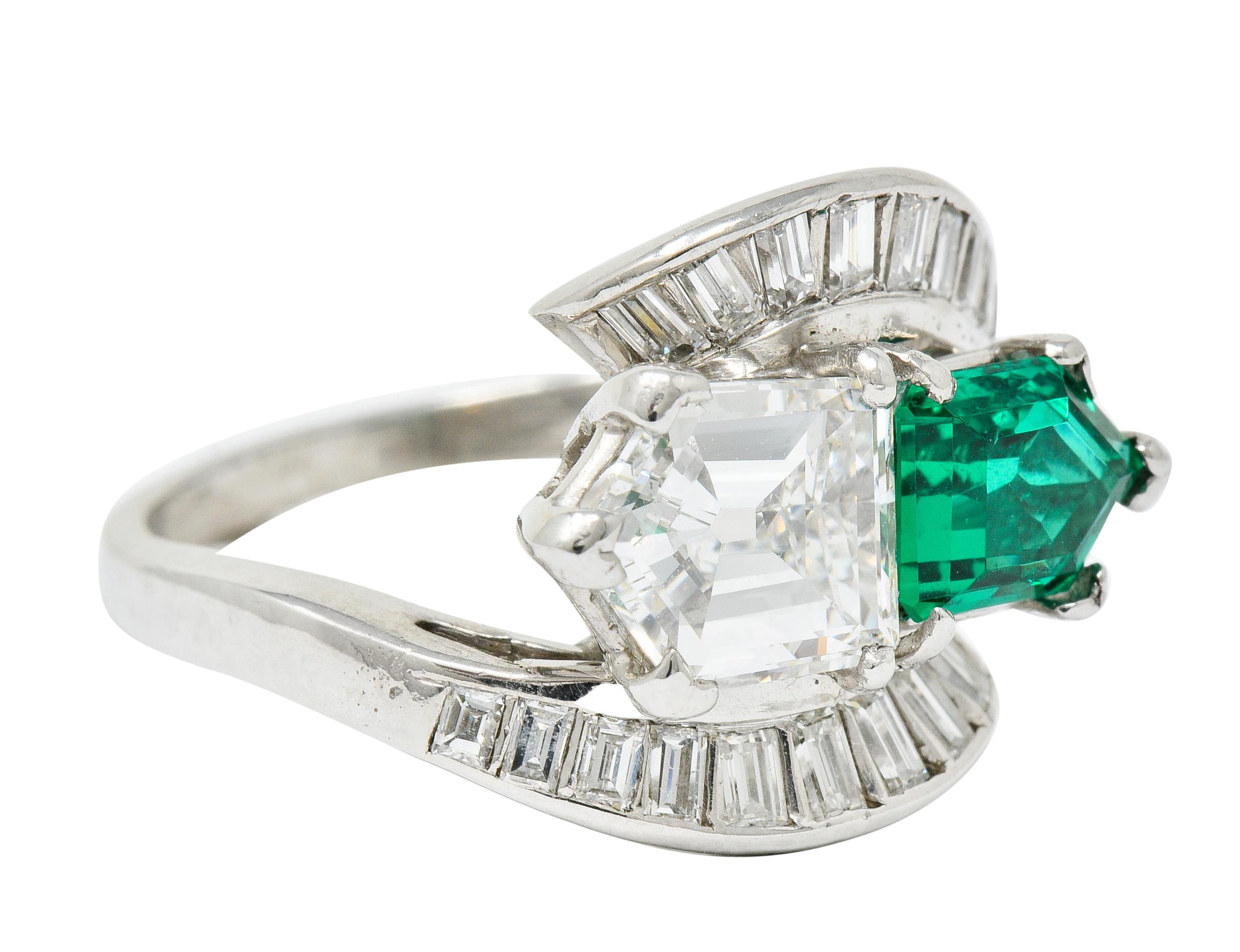 Bypass style ring centering a bullet cut emerald and a bullet cut diamond

Diamond weighs approximately 1.65 carat with F color and VS clarity

Emerald weighs approximately 1.00 carat with very transparent deep green color

Flanked by channel set