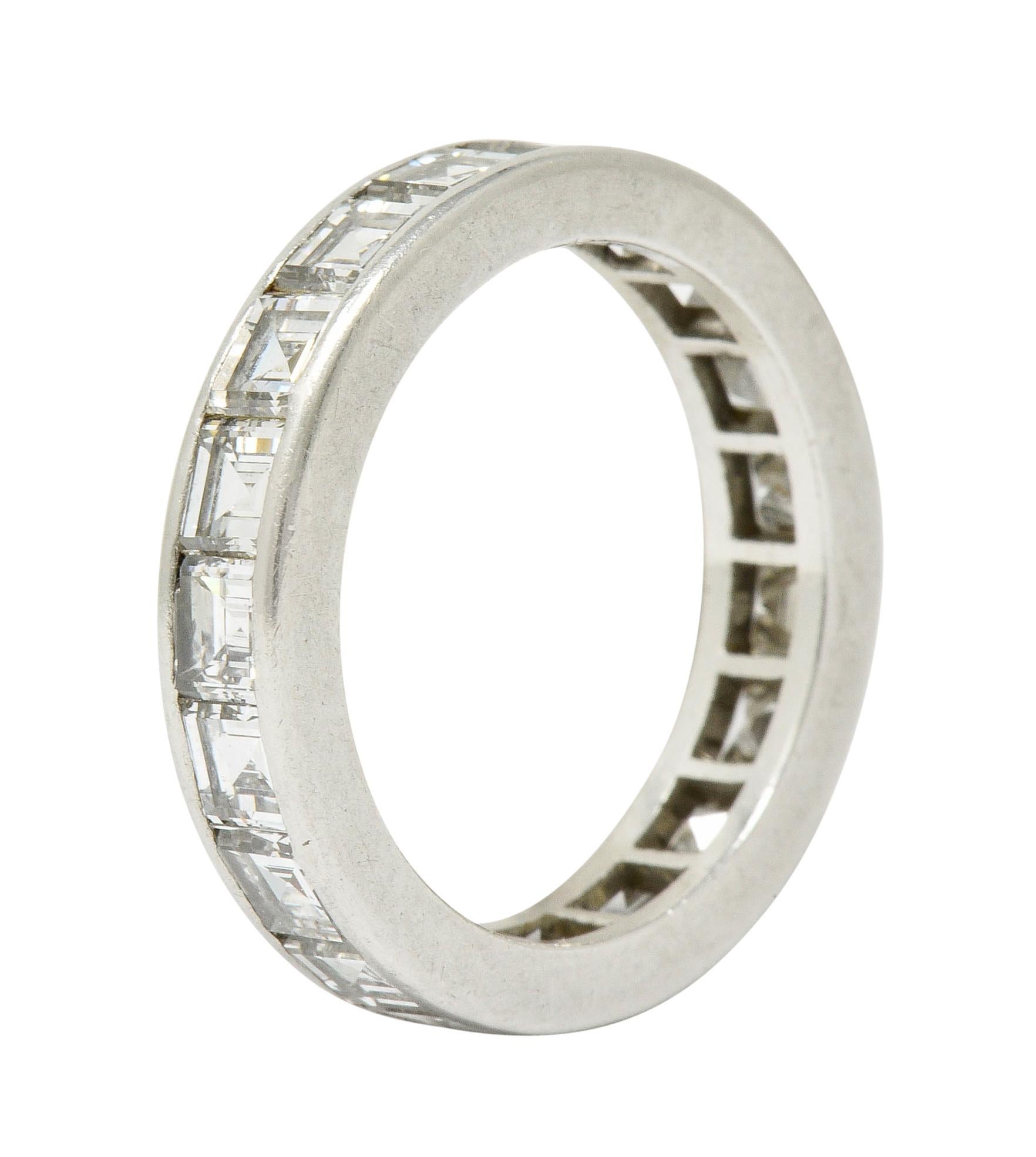 Eternity band ring is channel set fully around by rectangular step cut diamonds

Weighing in total approximately 3.80 carats with G to I color and VS clarity

Tested as platinum

Circa: 1950s

Ring Size: 7 1/2 & not sizable

Measures: 4.5 mm wide