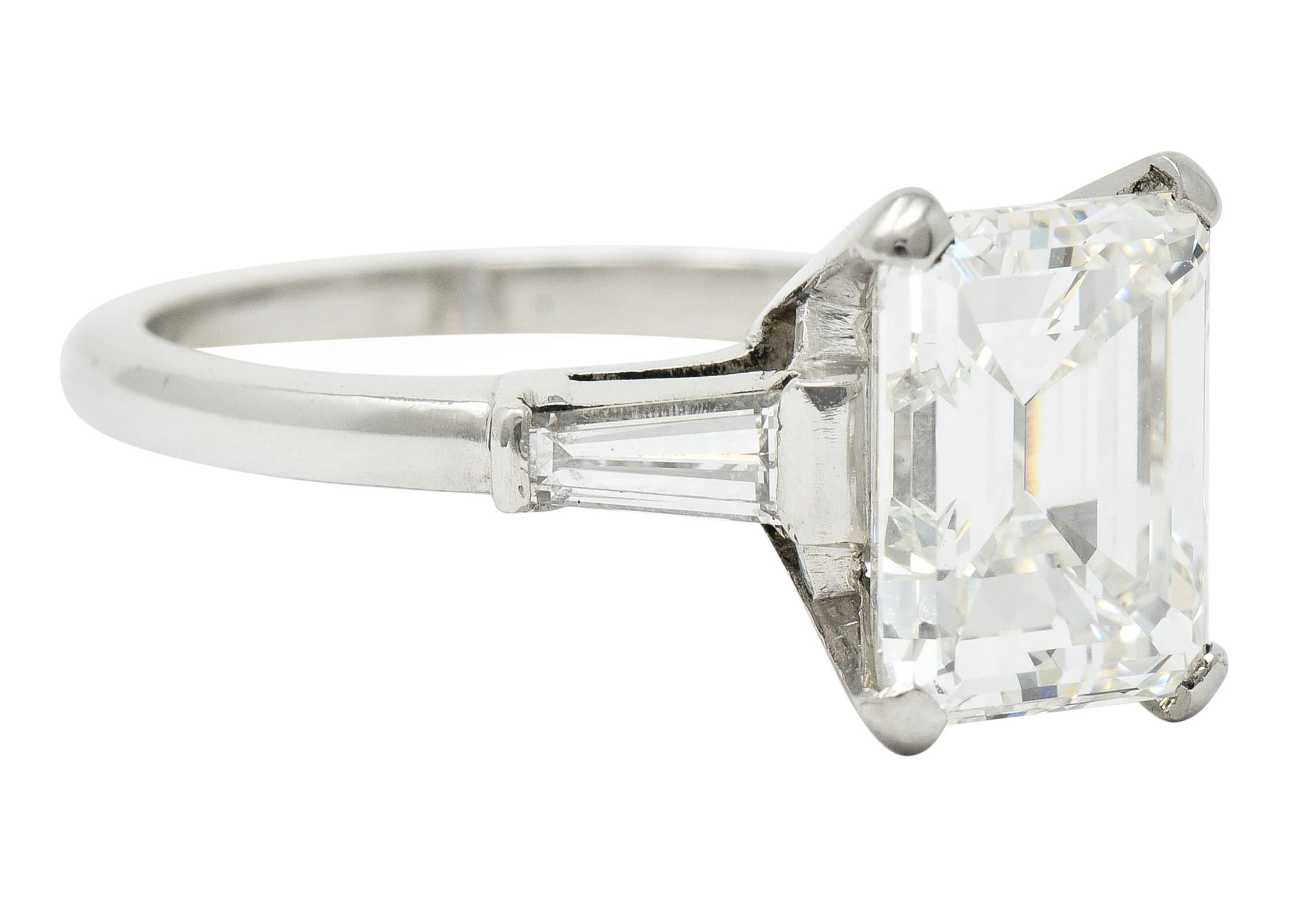 Centering an emerald cut diamond weighing 3.80 carats with I color and VS1 clarity

Basket set and flanked by tapered baguette cut diamonds

Weighing in total approximately 0.32 carat and well-matched to center

Stamped for platinum

Circa: