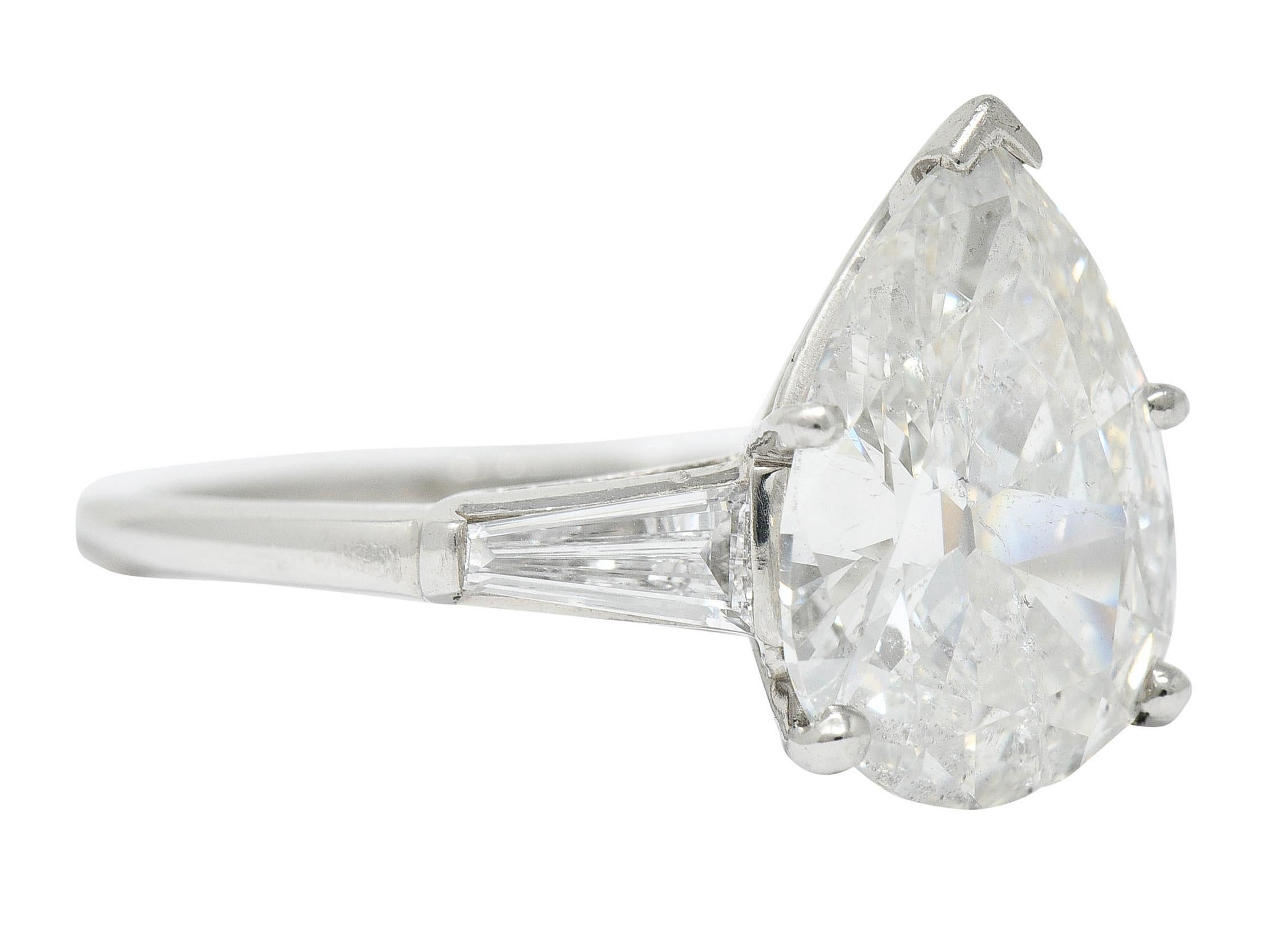Cathedral basket ring centers a pear shaped brilliant cut diamond weighing 3.89 carats - I color with I2 clarity

Flanked by two tapered baguette cut diamonds weighing in total 
approximately 0.50 carat - H/I color with VS clarity

With maker's mark