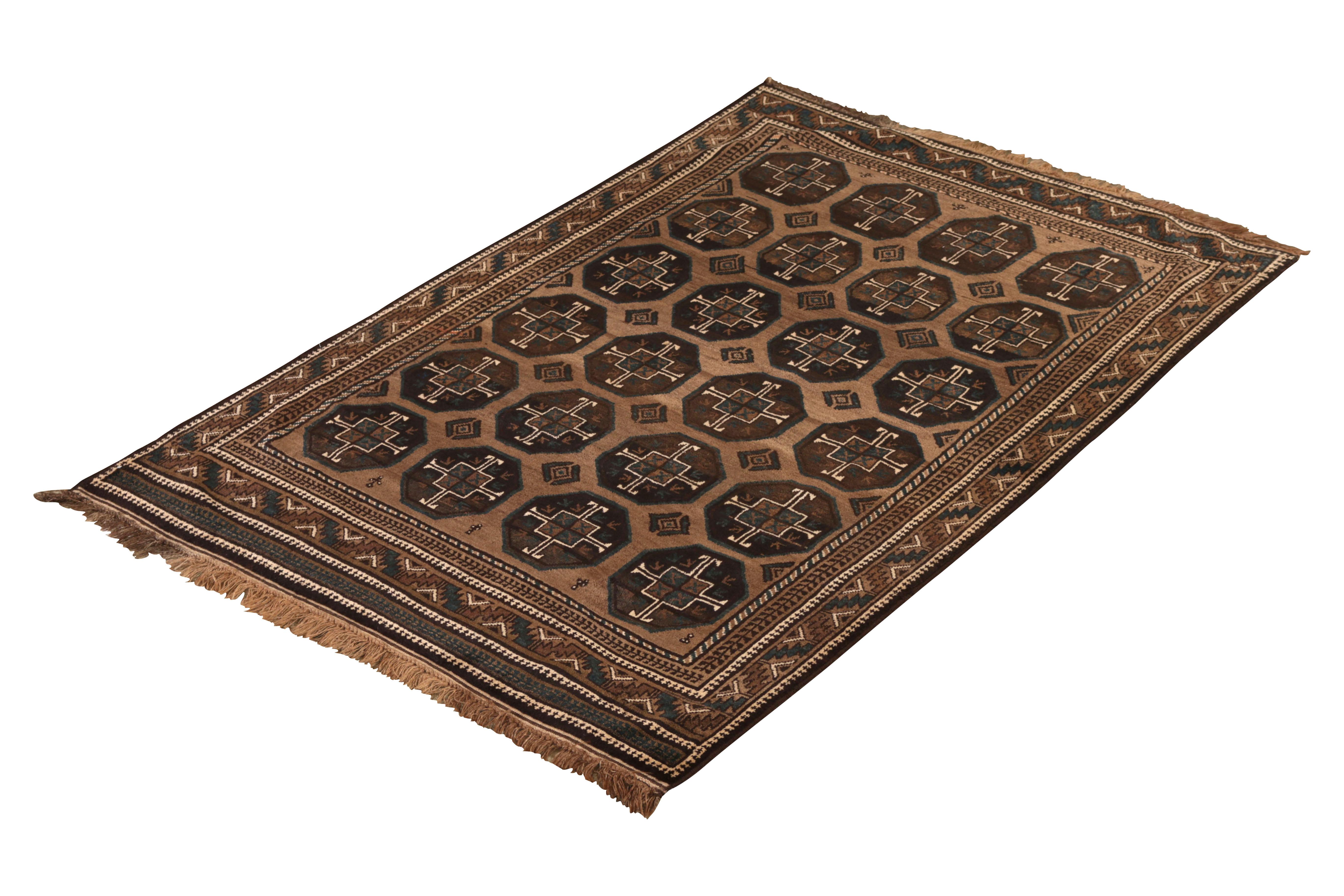 Hand knotted in wool originating from Persia circa 1950s, this antique rug connotes a distinctive Baluch tribal rug design, celebrated for bold geometry and rustic, rich colorway renown among Classic Persian rug families. This particular