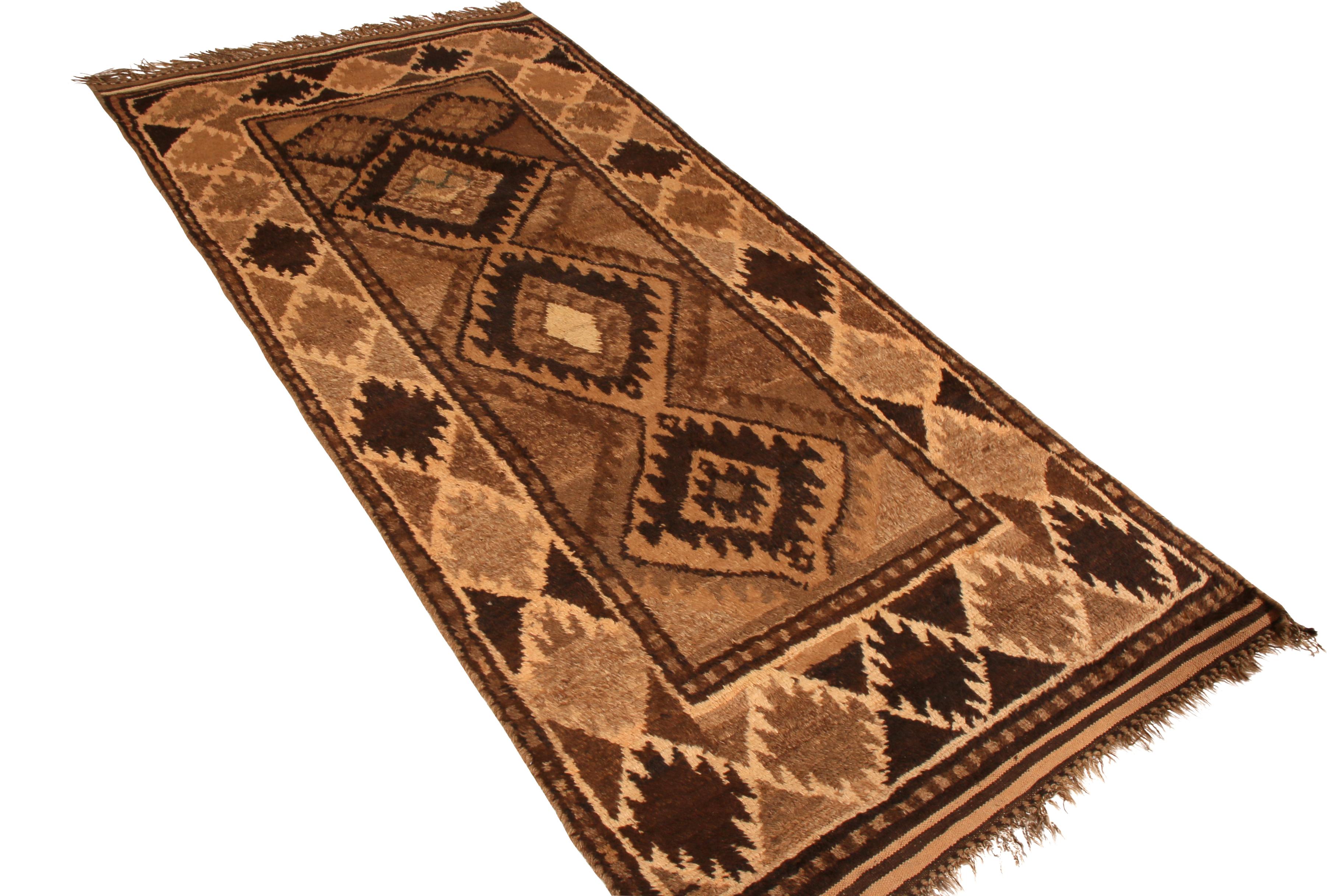 Hand knotted in wool originating circa 1950-1960 from the Baluch tribal weavers, this mid-century Persian rug marries a Classic diamond medallion pattern with the celebrated, rustic charm of beige brown enjoyed in this acclaimed tribal rug family;
