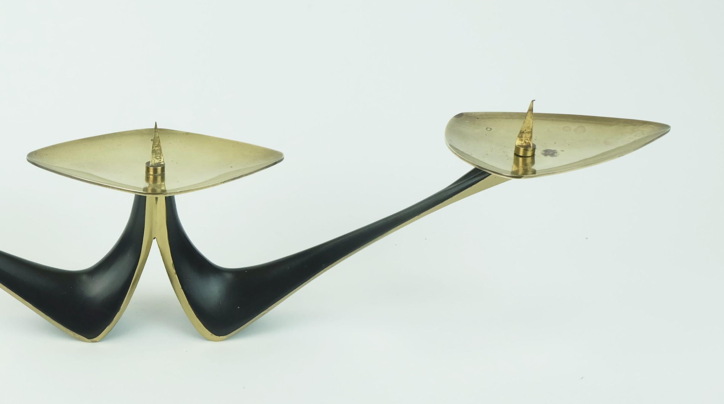 Portacandele moderno di metà secolo progettato dall'orafo e designer industriale tedesco Klaus Ullrich nel 1958 e prodotto da Faber & Schumacher Duisburg. 
Realizzato in ottone, parzialmente laccato in nero opaco. Design essenziale, un'aggiunta