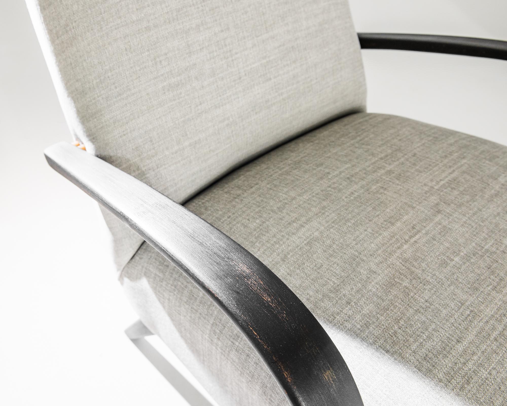 Une paire de fauteuils du designer de meubles tchèque Jindrich Halabala. Ce modèle des années 1950 est tapissé d'un tissu beige actualisé. Ce ton terreux et apaisant a été choisi pour compléter le noir texturé du cadre en bois dur. Influencées par