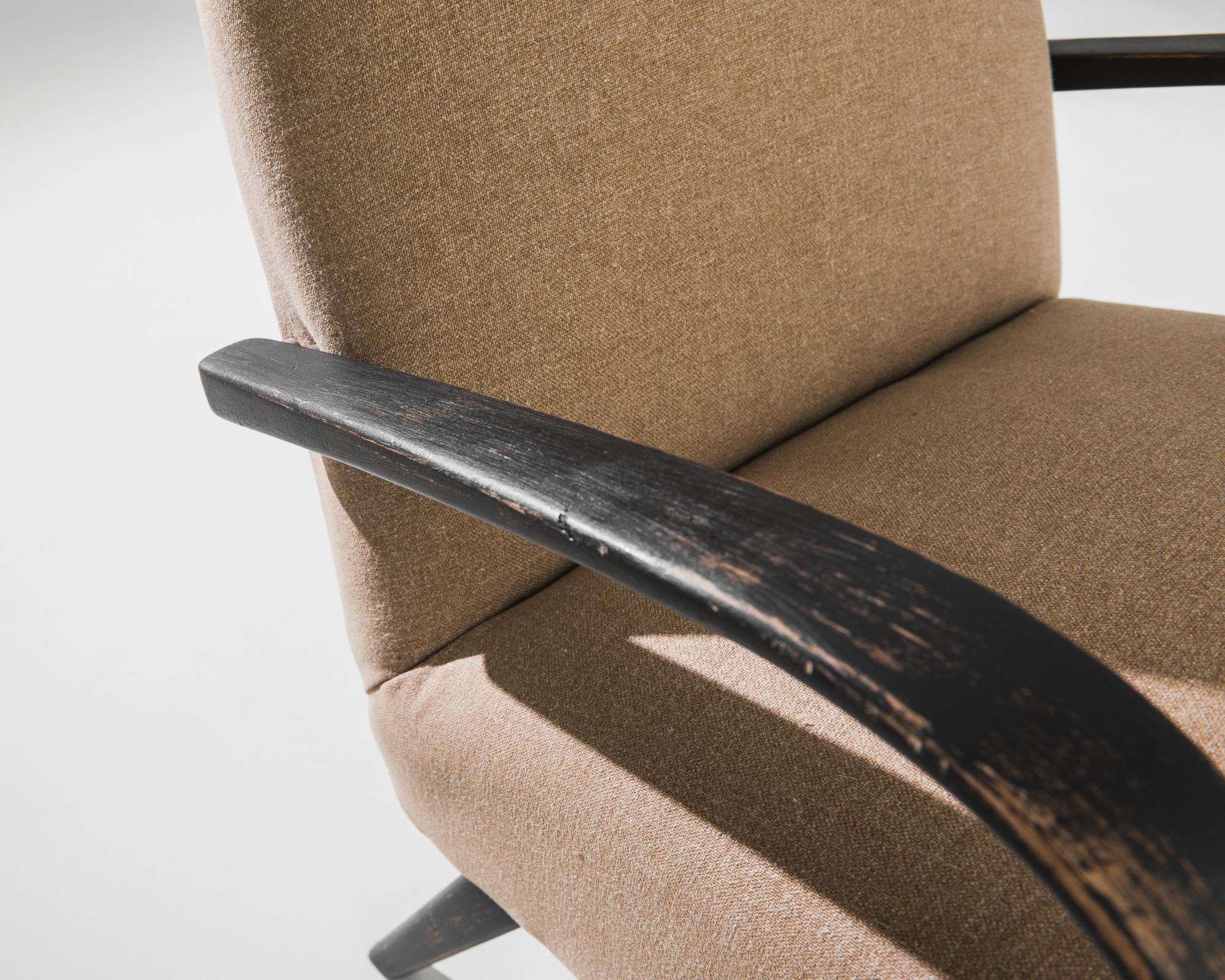 Un fauteuil du designer de meubles tchèque Jindrich Halabala. Ce modèle des années 1950 est revêtu d'un tissu marron moderne. Ce ton de terre apaisant a été choisi pour compléter le noir texturé de la structure en bois dur. Influencées par le design