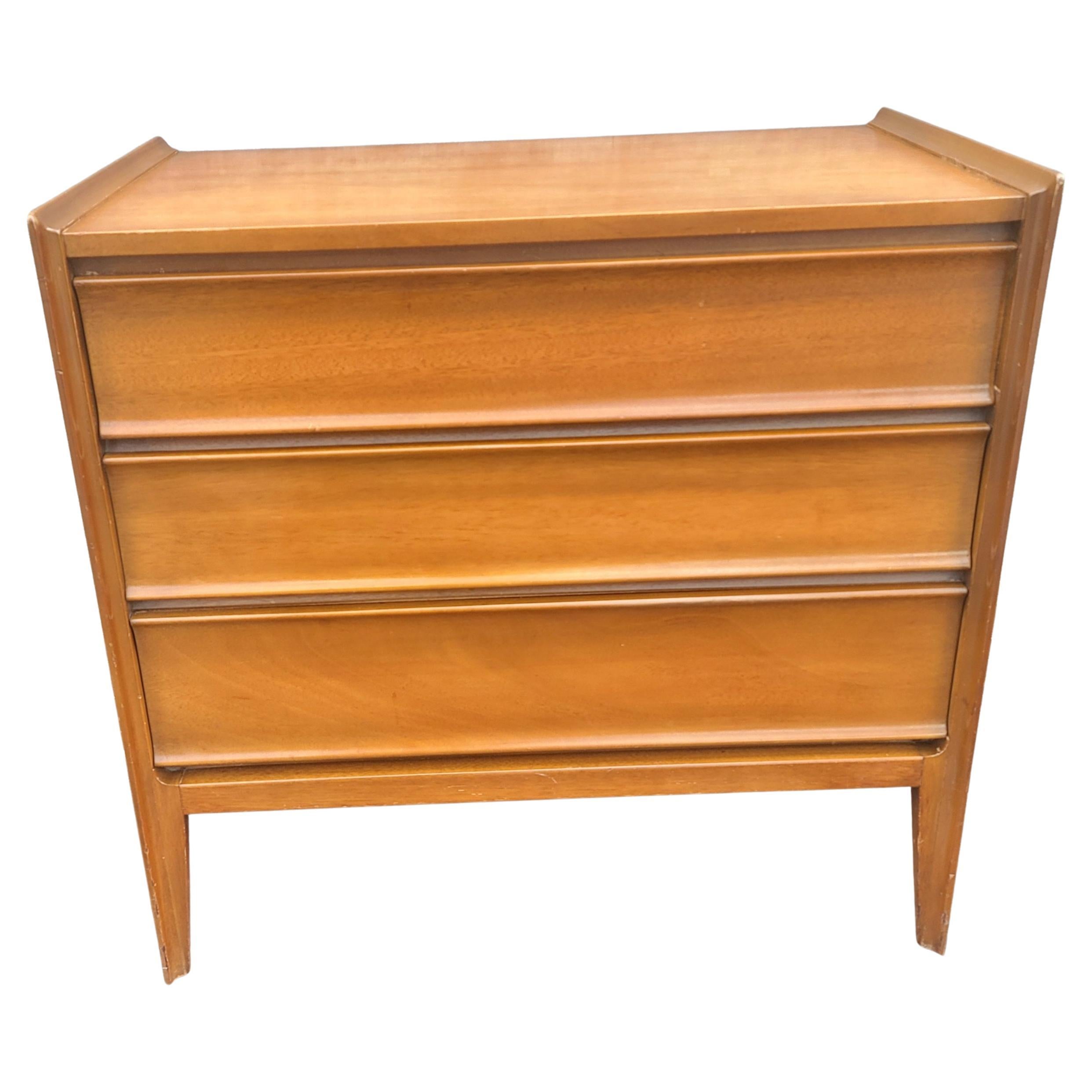 A 1950s Mid-Century Danish Modern Teak United Furniture Chest of drawers with dovatail joints and sleek integrated drawer handles measuring 32