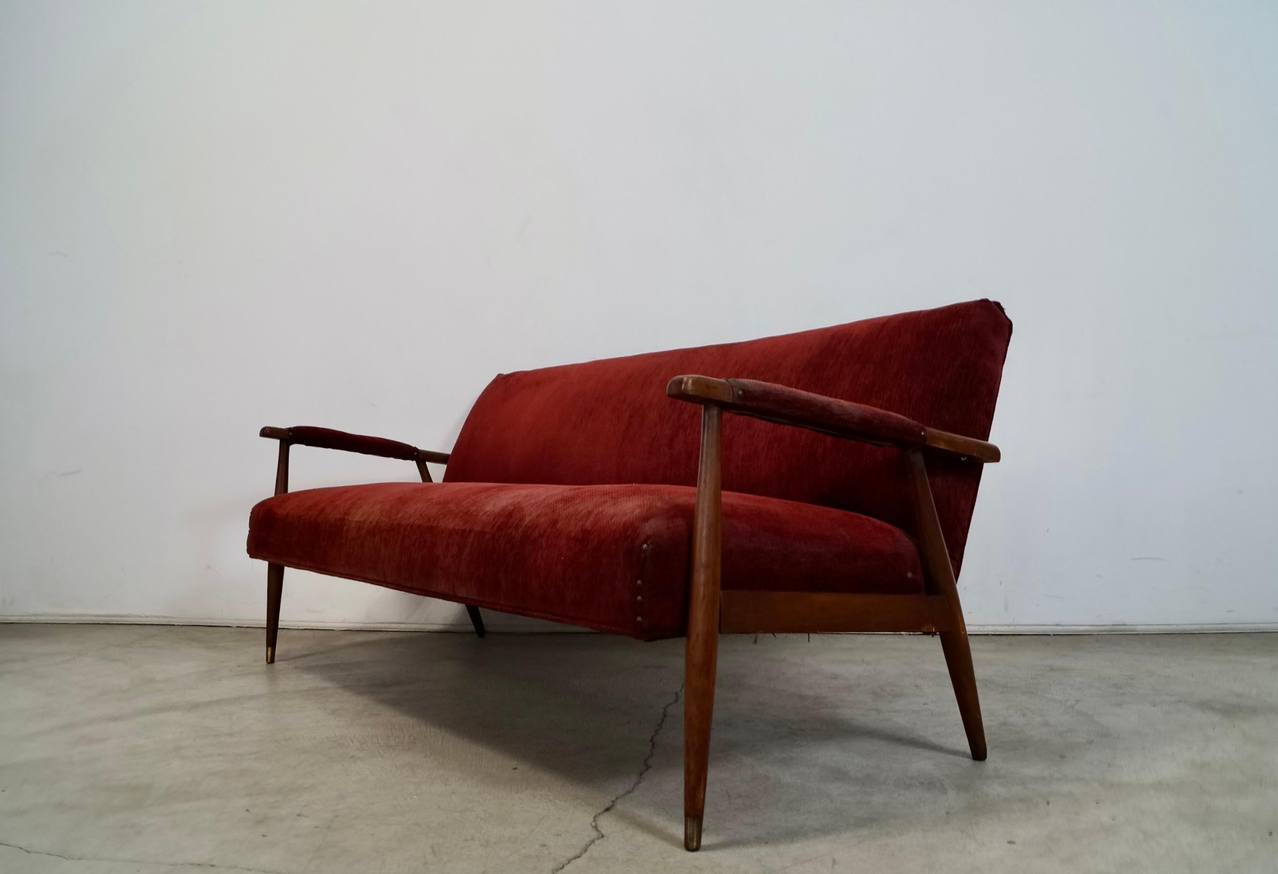 Se vende sofá vintage original de mediados de siglo de 1950. Tiene un diseño moderno danés escandinavo, y antes estaba retapizada. Tiene el clásico diseño danés con respaldo inclinado y patas cónicas. Las patas delanteras están rematadas en latón