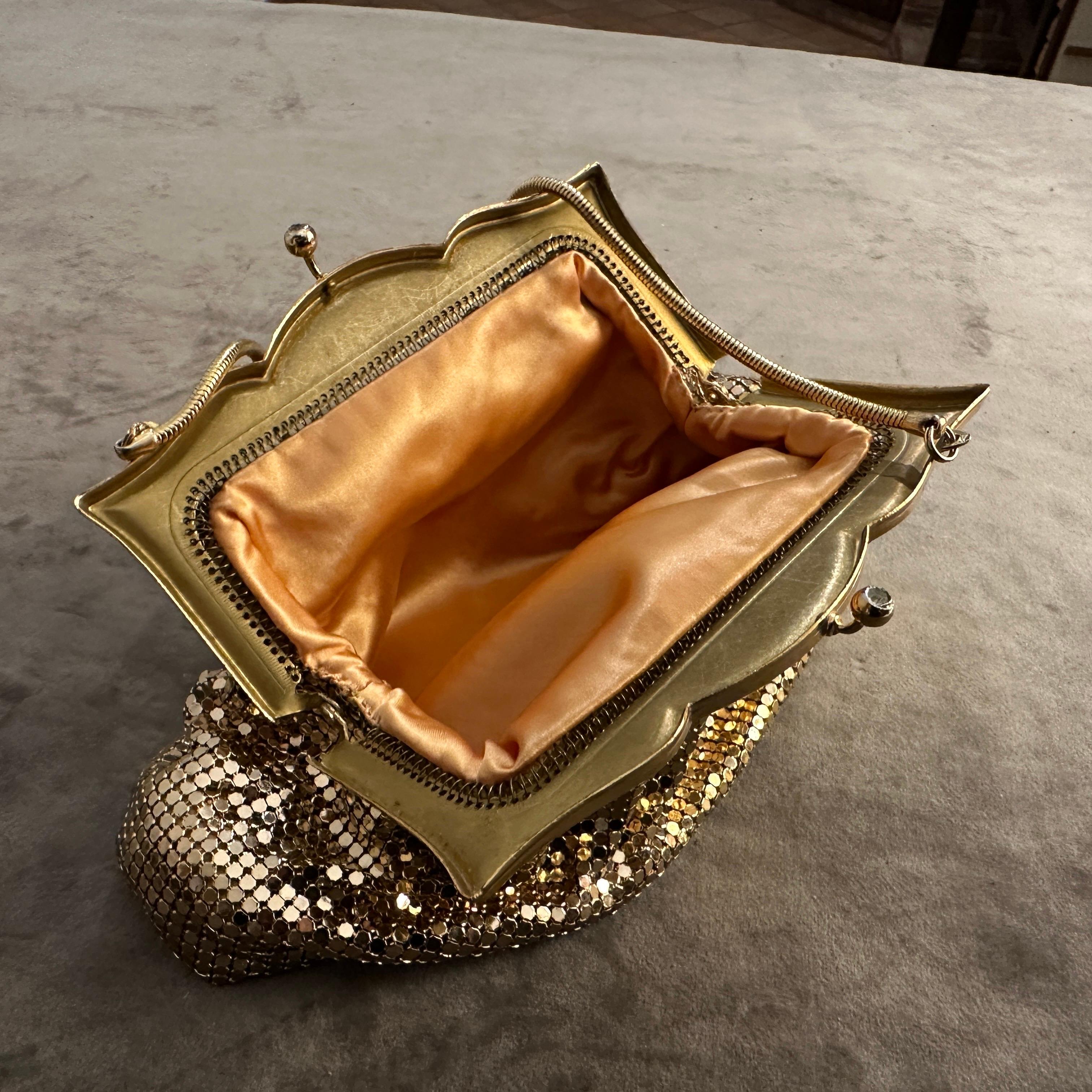 This 1950s gold metal mesh evening bag exemplifies the elegance and glitz of Mid-Century accessories. Its warm metallic sheen, classic kiss-lock frame, and petite size make it a timeless statement piece for formal or cocktail events.
The body is