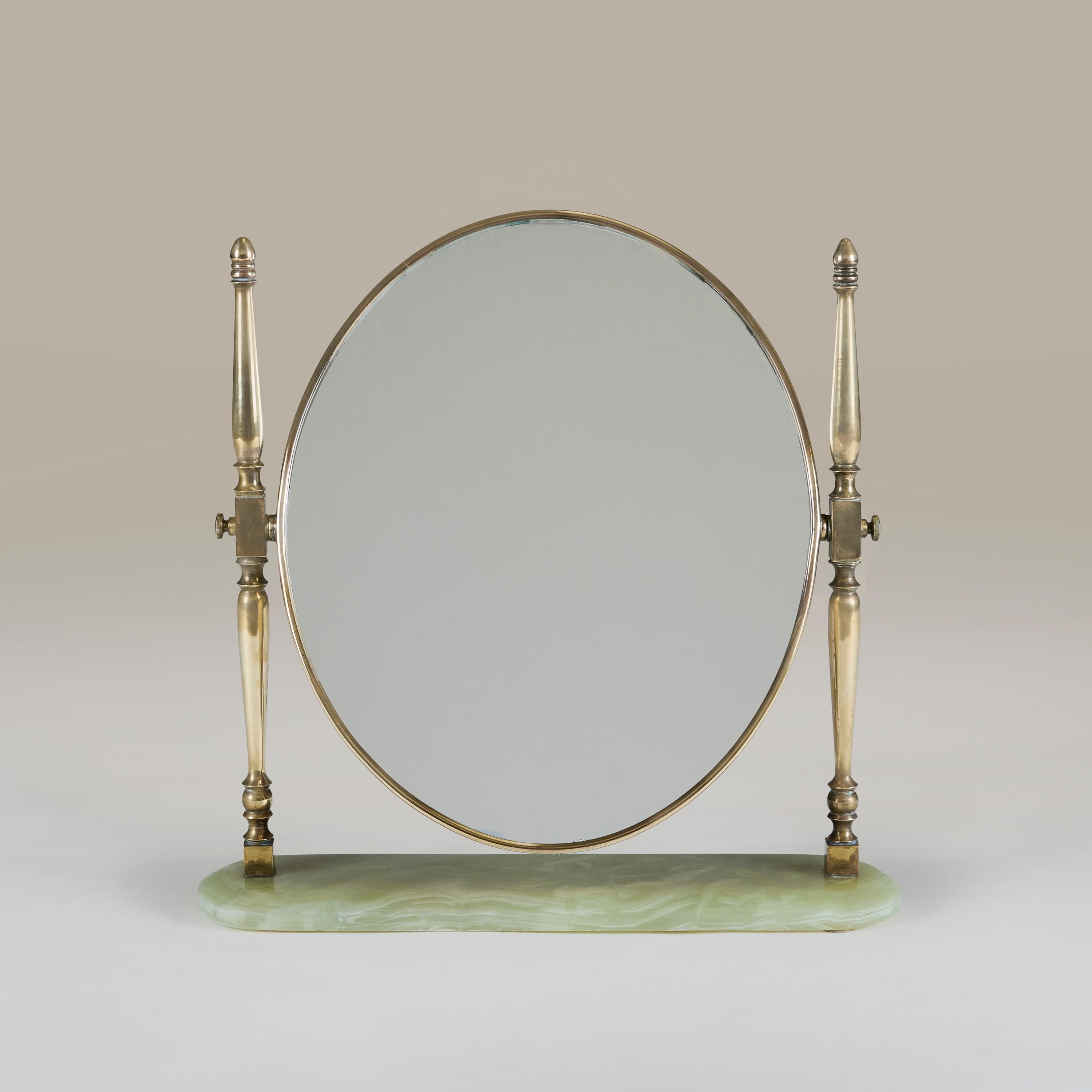 Elegant oval table mirror with solid brass frame. Decorative brass arms hold the mirror and allow it to be angled. Sits on green and cream mottled curved marble base. Designed and produced in Italy during the 1950s.   