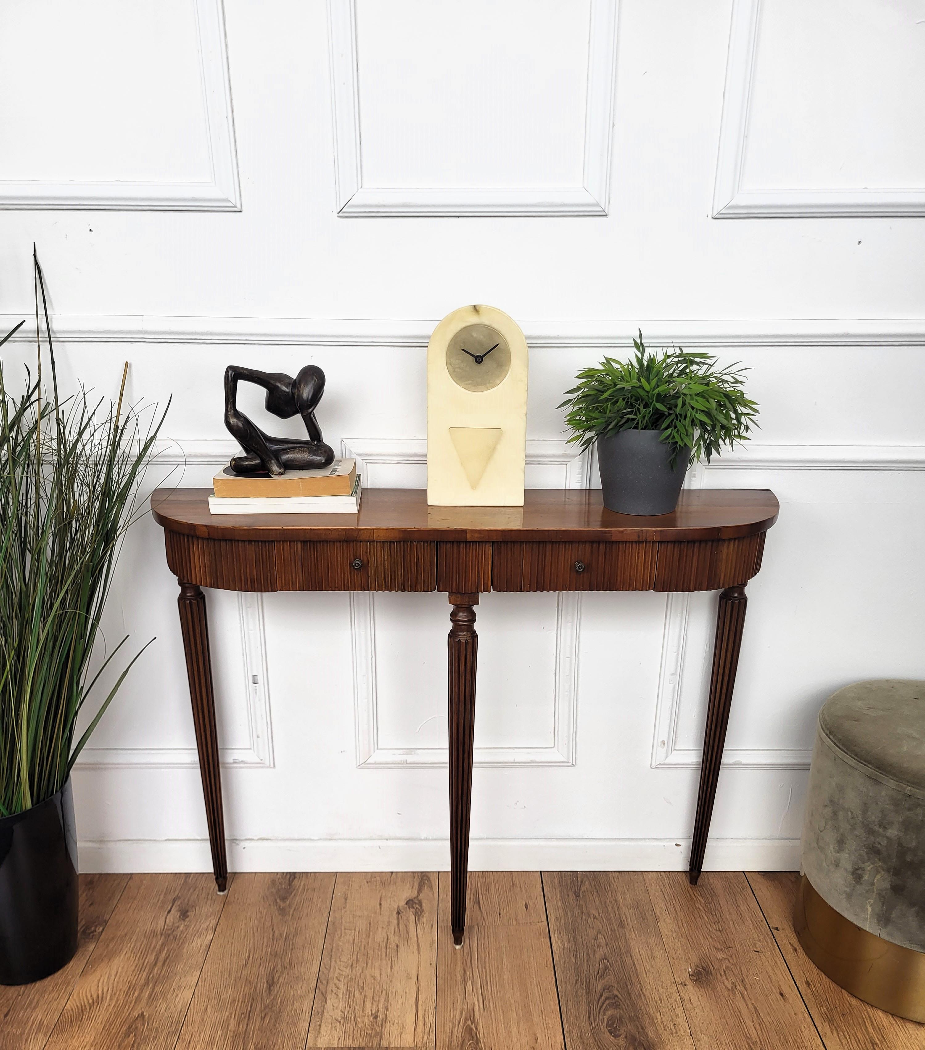 Very elegant and refined Italian 1950s Mid-Century Modern and neoclassical design console table highlighted by the slatted workmanship of the wooden front part and drawers. The three elegantly shaped legs give this console an extremely light and