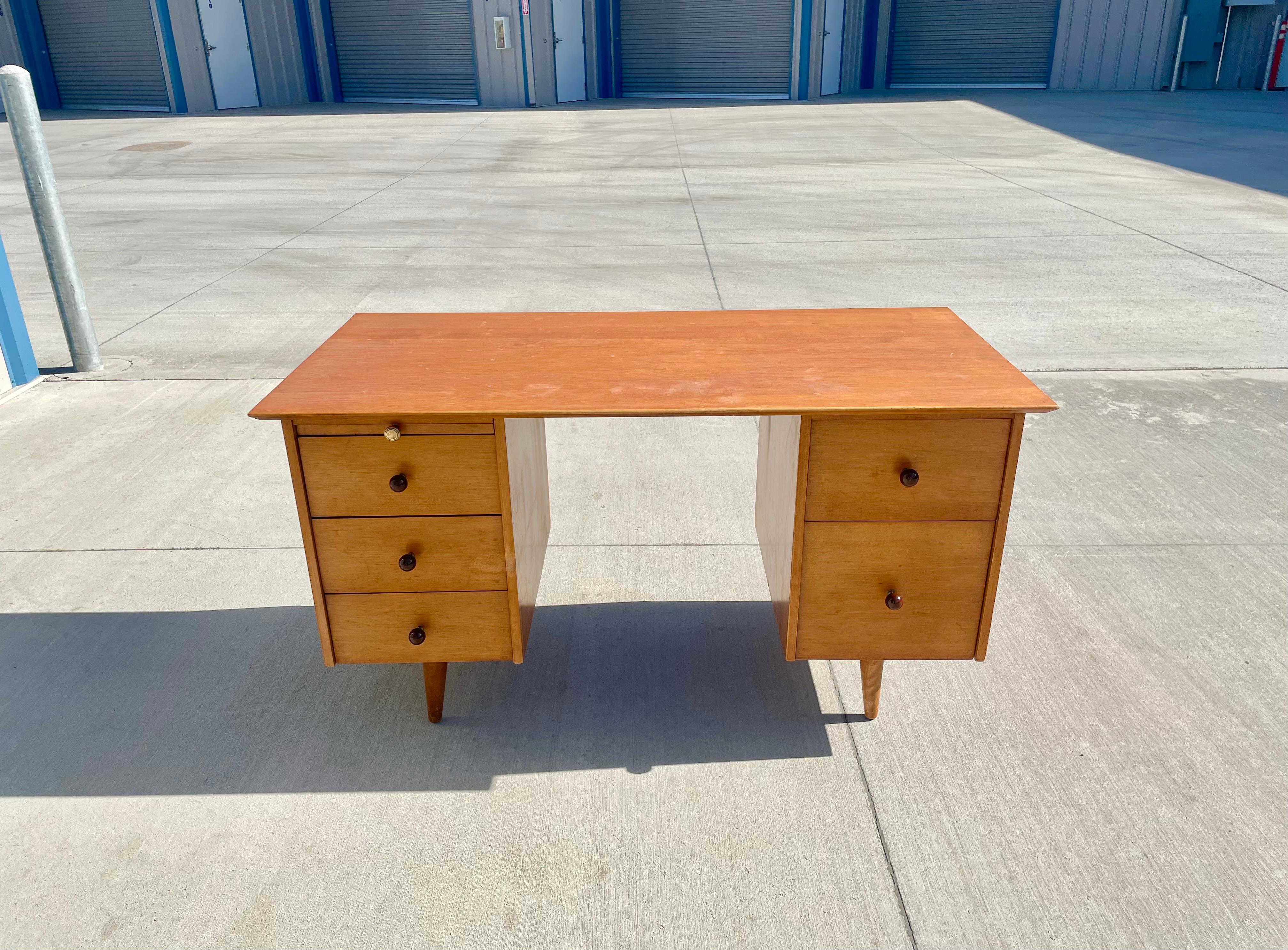 Midcentury maple double pedestal desk by Paul McCobb for Planner Group manufactured in the United States, circa 1950s. This vintage desk is beautifully constructed from the finest maple wood. The desk has three drawers on the left and two on the