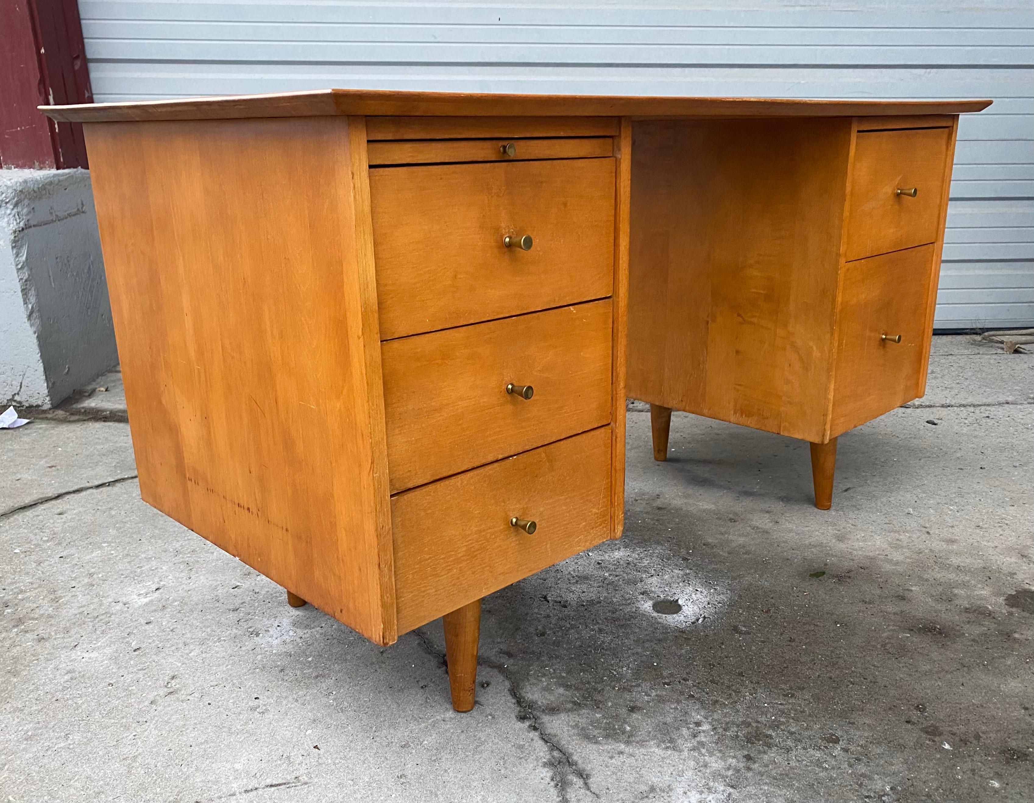 Midcentury maple double pedestal desk by Paul McCobb for Planner Group manufactured in the United States, circa 1950s. This modernist desk is beautifully constructed from the finest maple wood. The desk has three drawers on the left , pull out