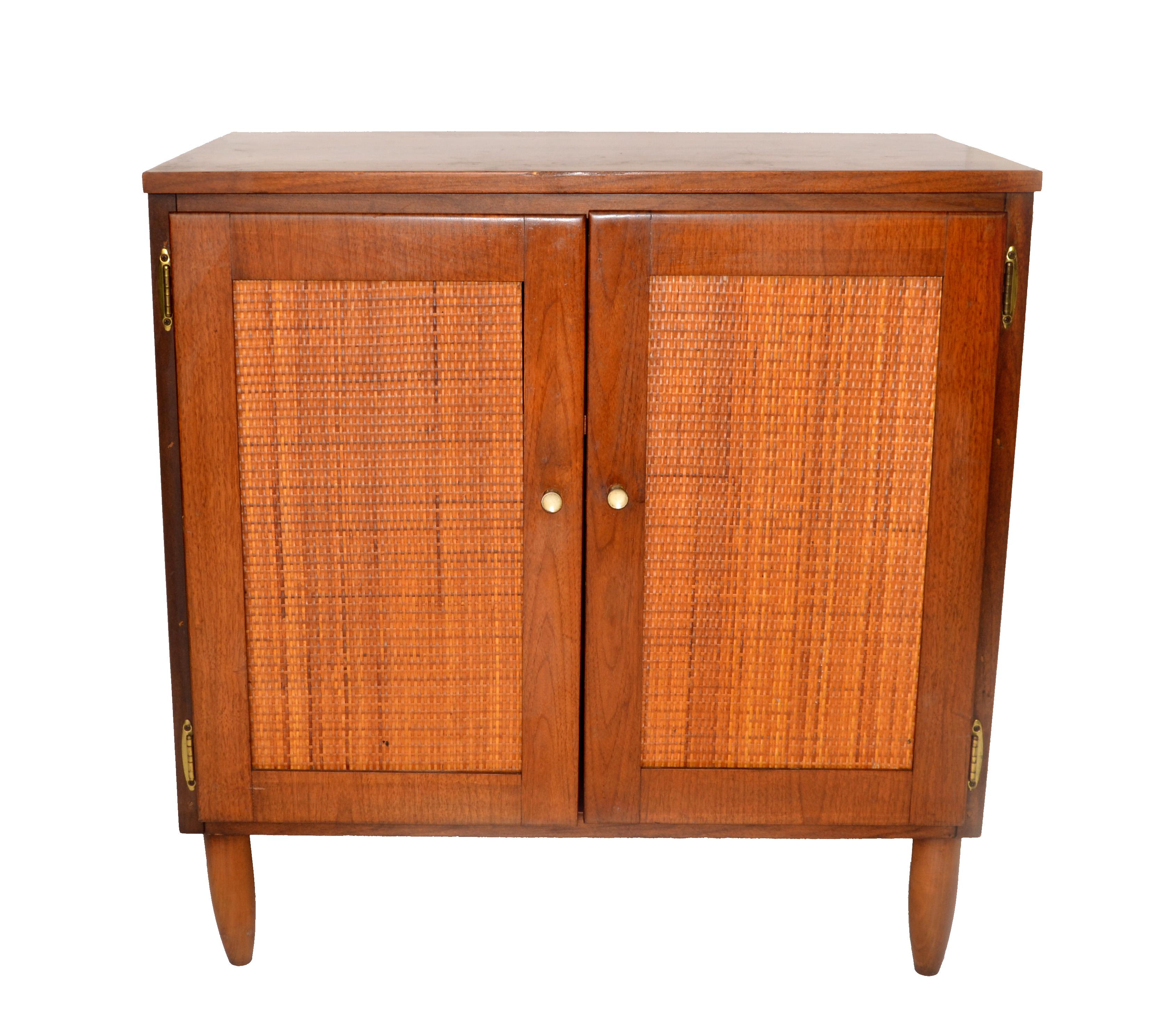 Charming 1950s Mid-Century Modern Chest, cabinet in Wood with 2 handwoven Doors.
The Interior features one shelf with plenty of storage space and the knobs are made out of Brass.
This Cabinet is perfect for small Living Settings.