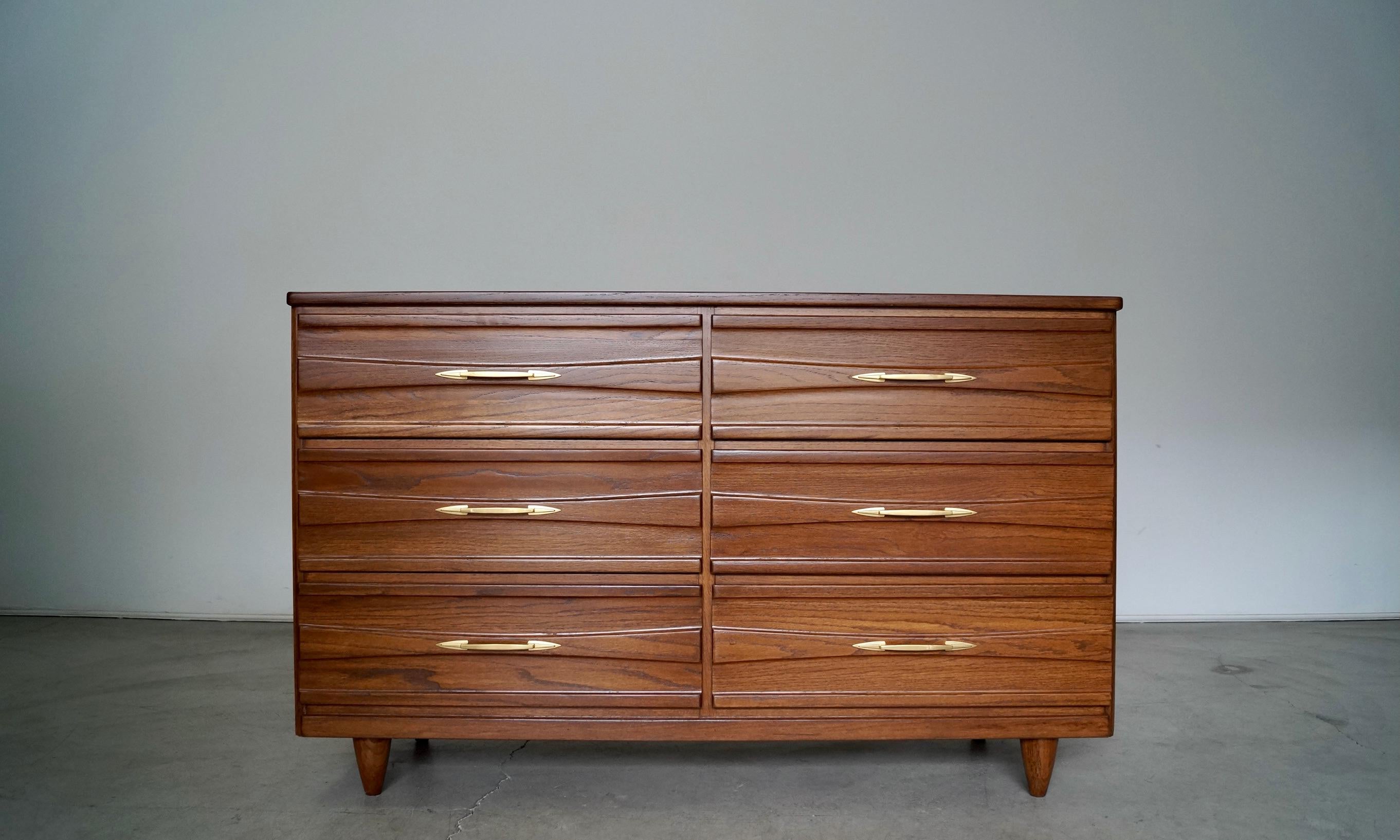 Vintage original Mid-Century Modern dresser for sale. Manufactured in the 1950's, and constructed of solid ash. It has been professionally refinished in walnut, and is a great size. It has six total drawers dovetailed on both ends, and still has the