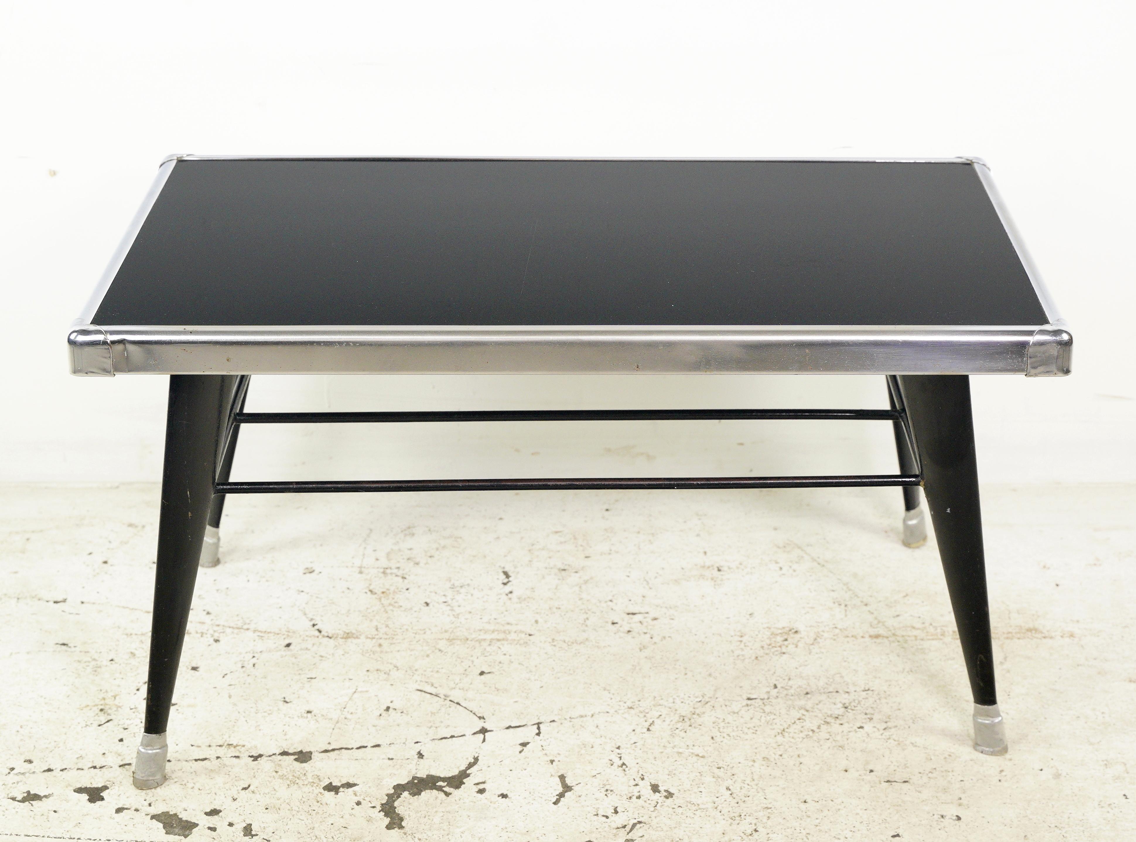 A European Mid-Century Modern coffee table from the 1950s, crafted with a combination of glass and steel. This piece reflects the design sensibilities of the era, offering a stylish and functional addition to living spaces with its unique blend of