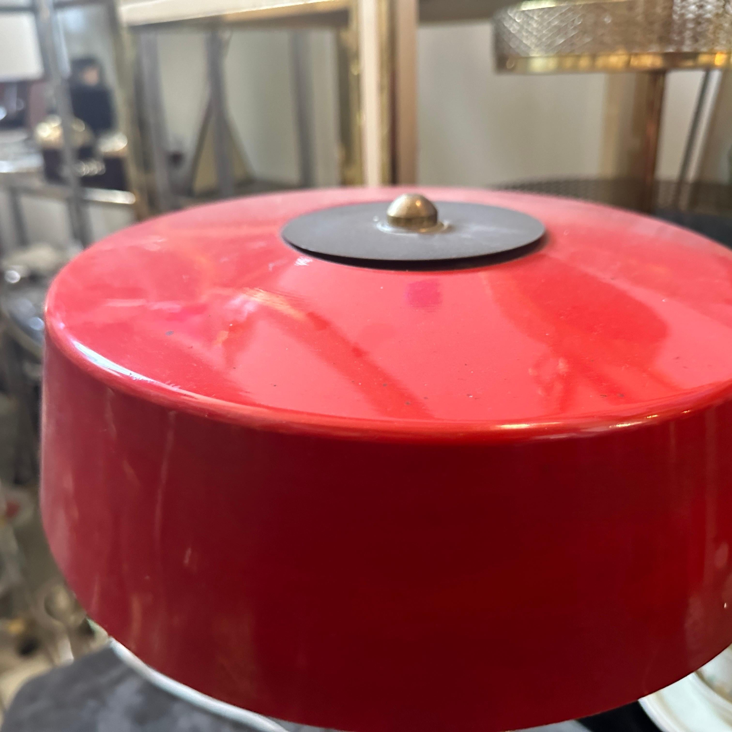 This is a 1950s Mid-Century Modern Italian table lamp, featuring a combination of brass and red-painted metal. The design embodies the clean lines and sleek, functional aesthetics characteristic of the Mid-Century Modern style. The lamp has a