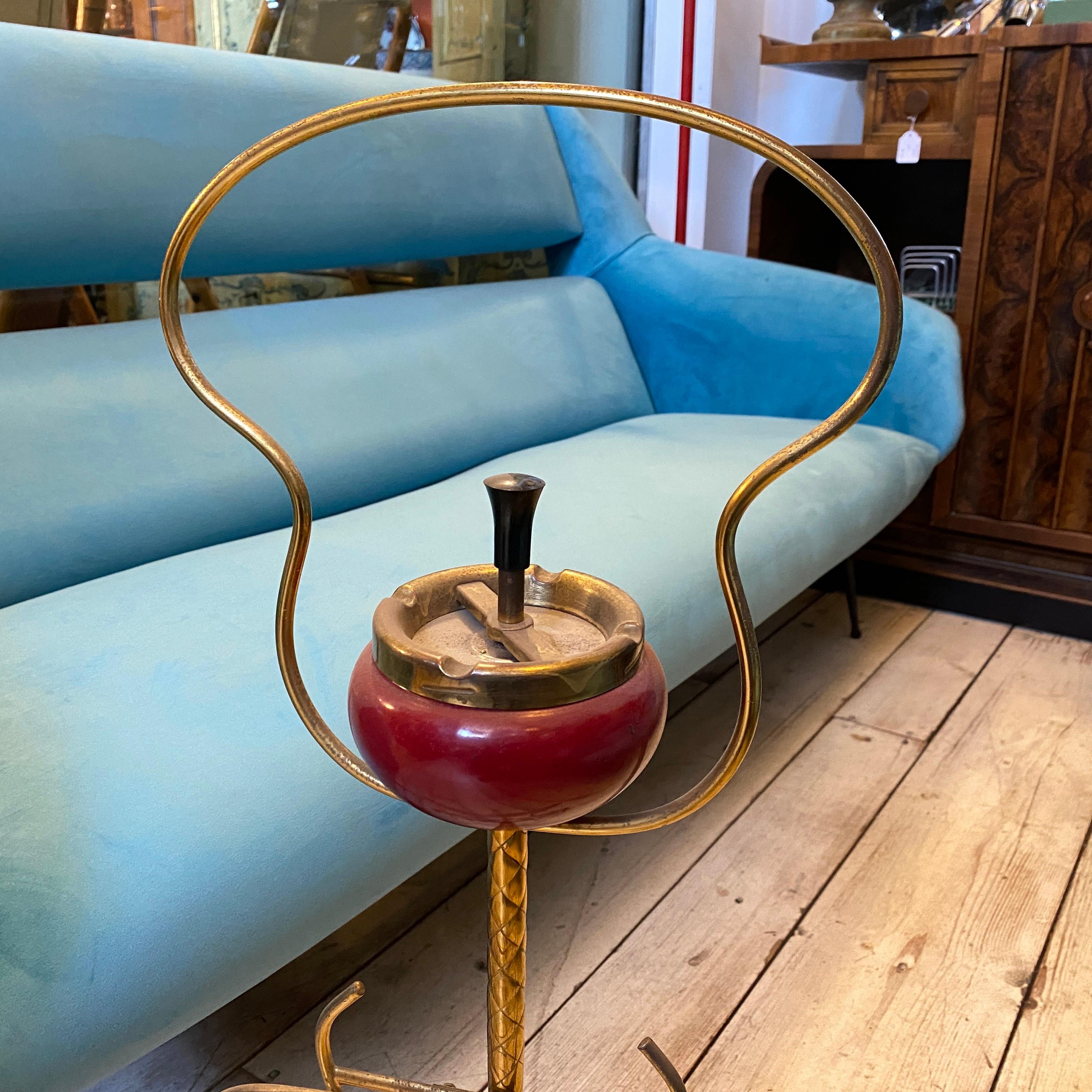 An italian brass tripode ashtray, usable near an armchair. It's in original nice vintage conditions and patina. The tripod ashtray is crafted from brass, a popular material choice during the Mid-Century Modern period for its durability and warm