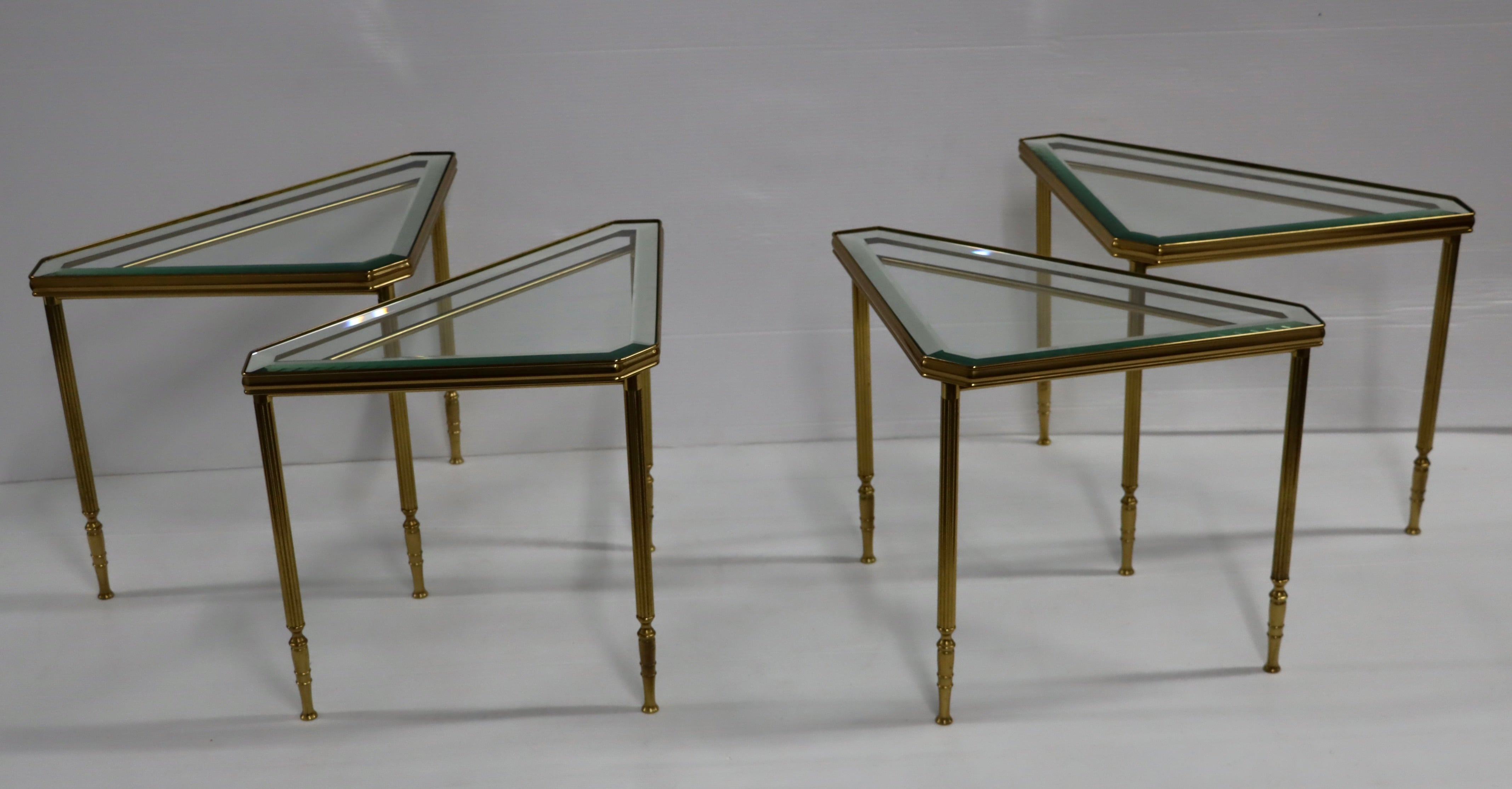 Set of 4 1950's solid brass Mid-Century Modern triangular side tables / coffee table with mirror edges glass inserts, in vintage original condition with some wear and patina due to age and use.