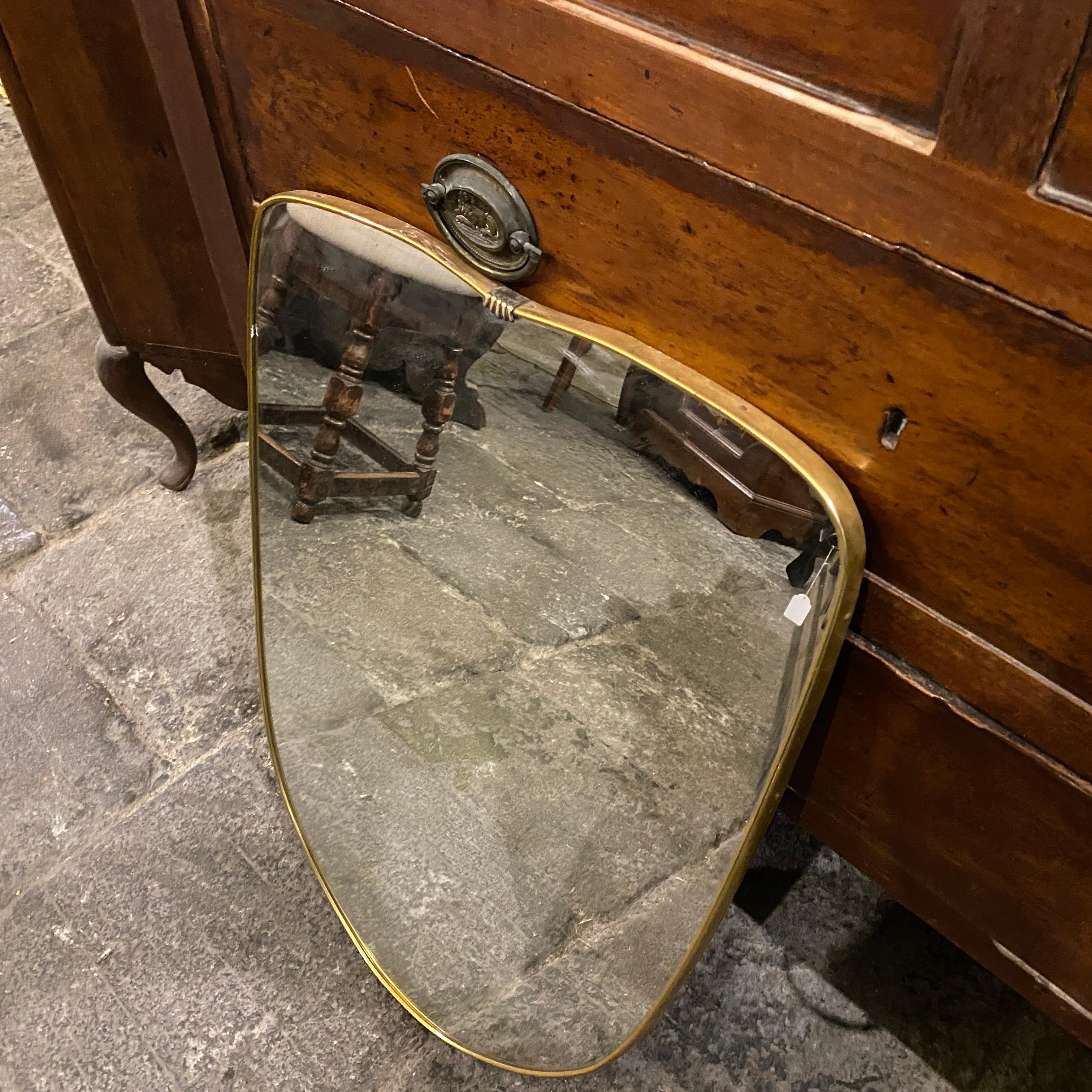 A Mid-Century Modern brass shield wall mirror made in Italy in the 1950s, good conditions overall.