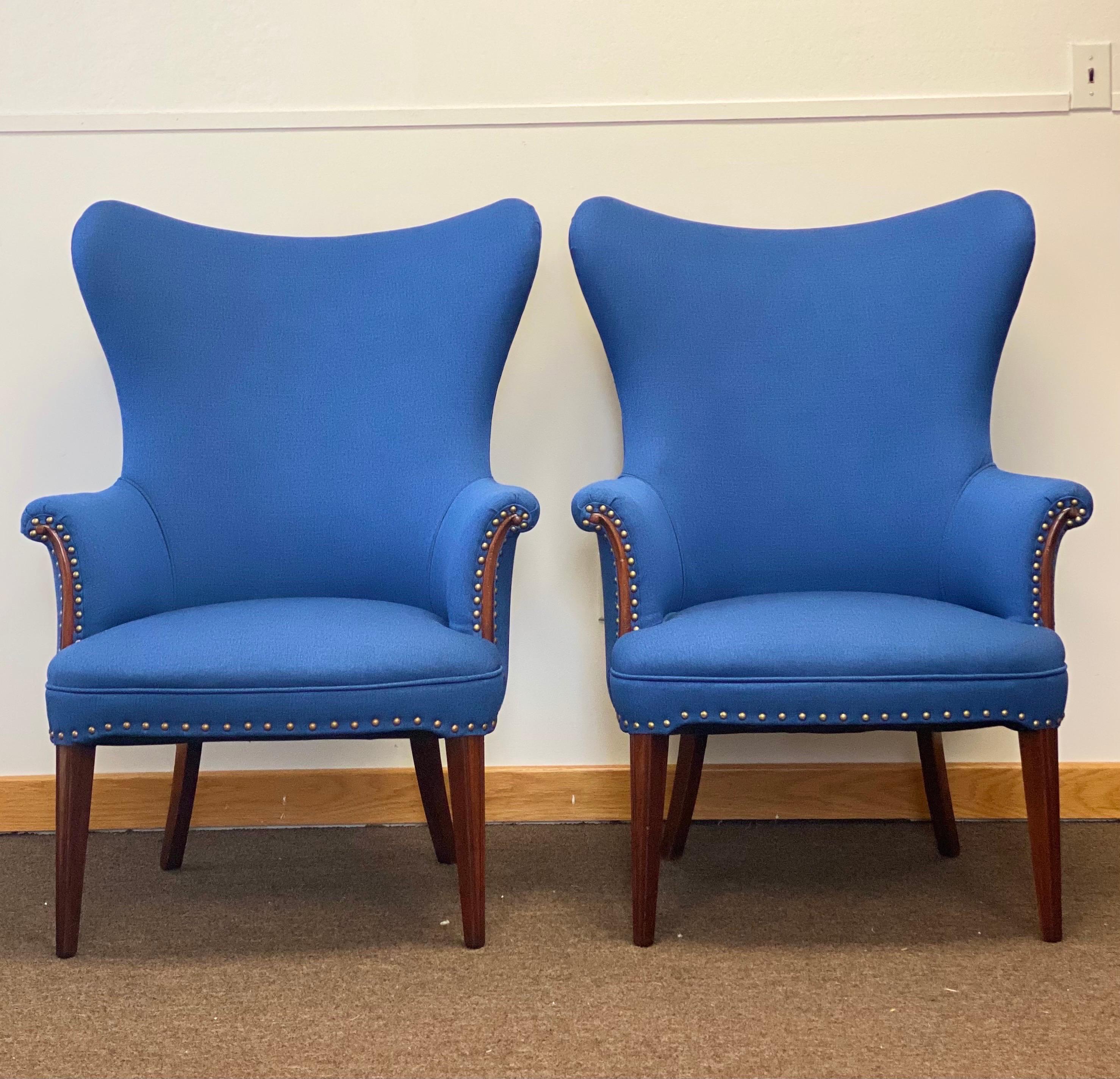 We are very pleased to offer a gorgeous, vintage pair of butterfly wingback chairs, circa the 1950s. This Scandinavian take on the classic wingback chair brings a graceful silhouette to any space. Padded wings and a generous seat offer an elegant